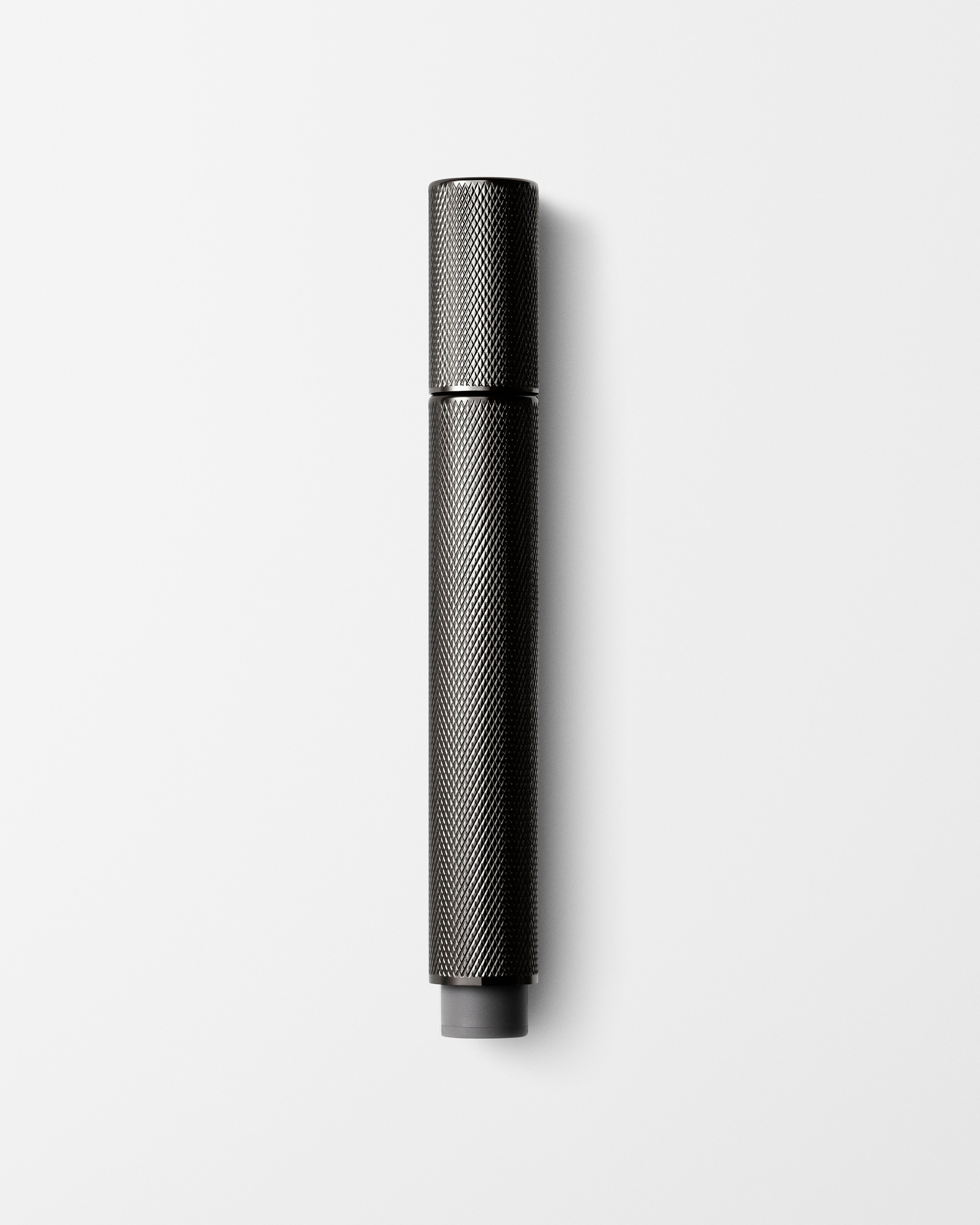 Tinted eye cream for men laying on a grey surface