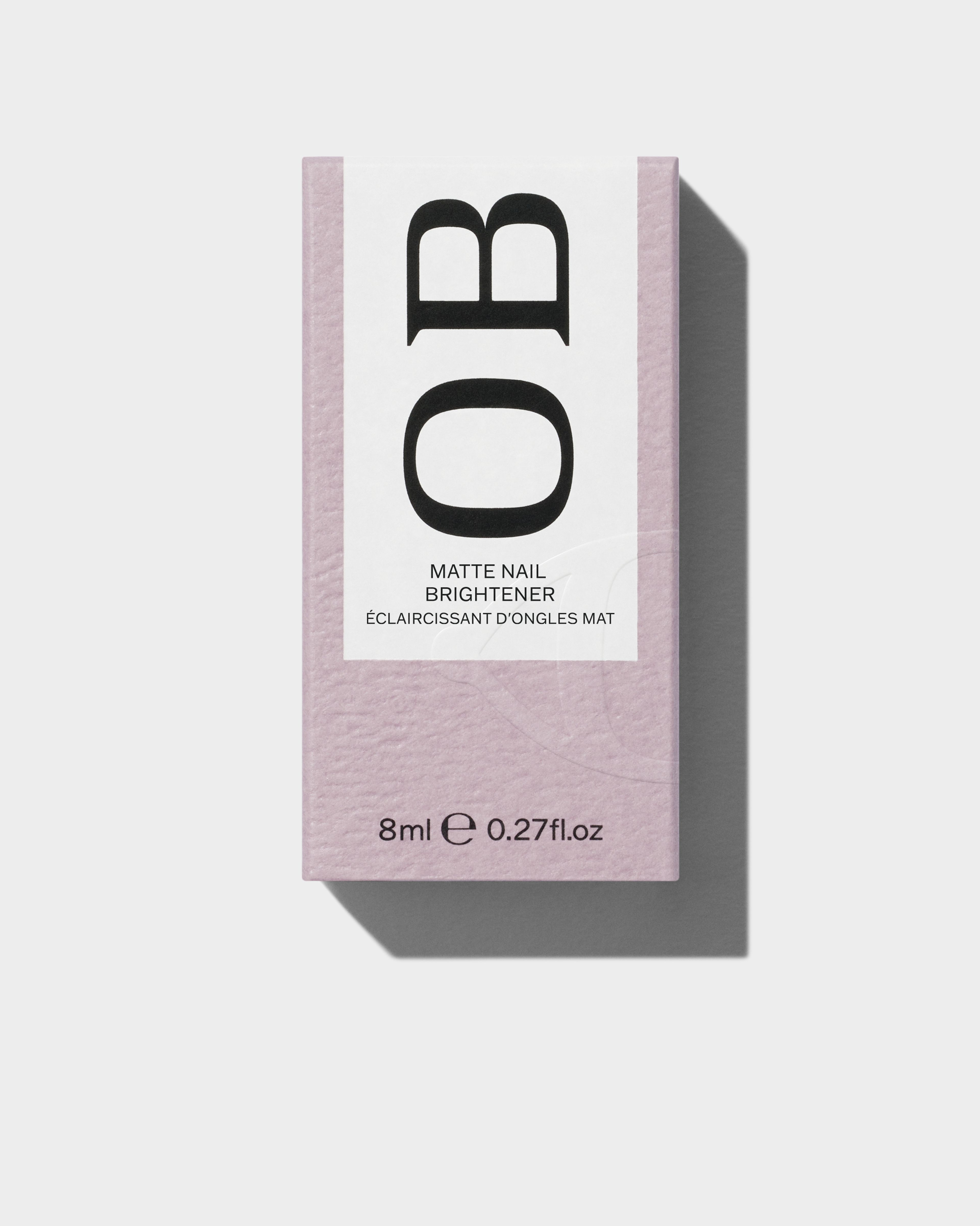 Matte Nail Brightener packaging laying on a grey surface