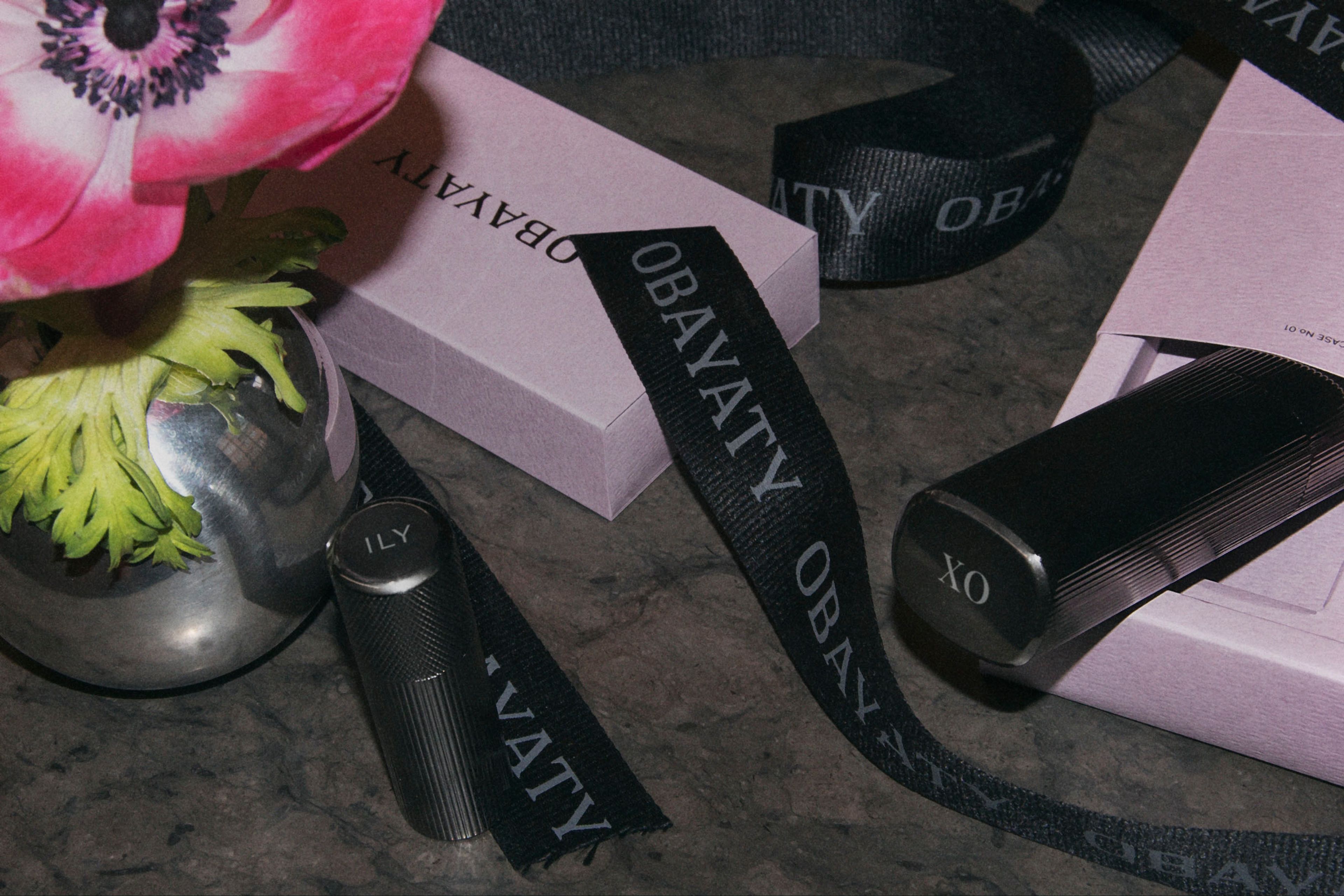 A flower, ribbons and various products laying on a stone table