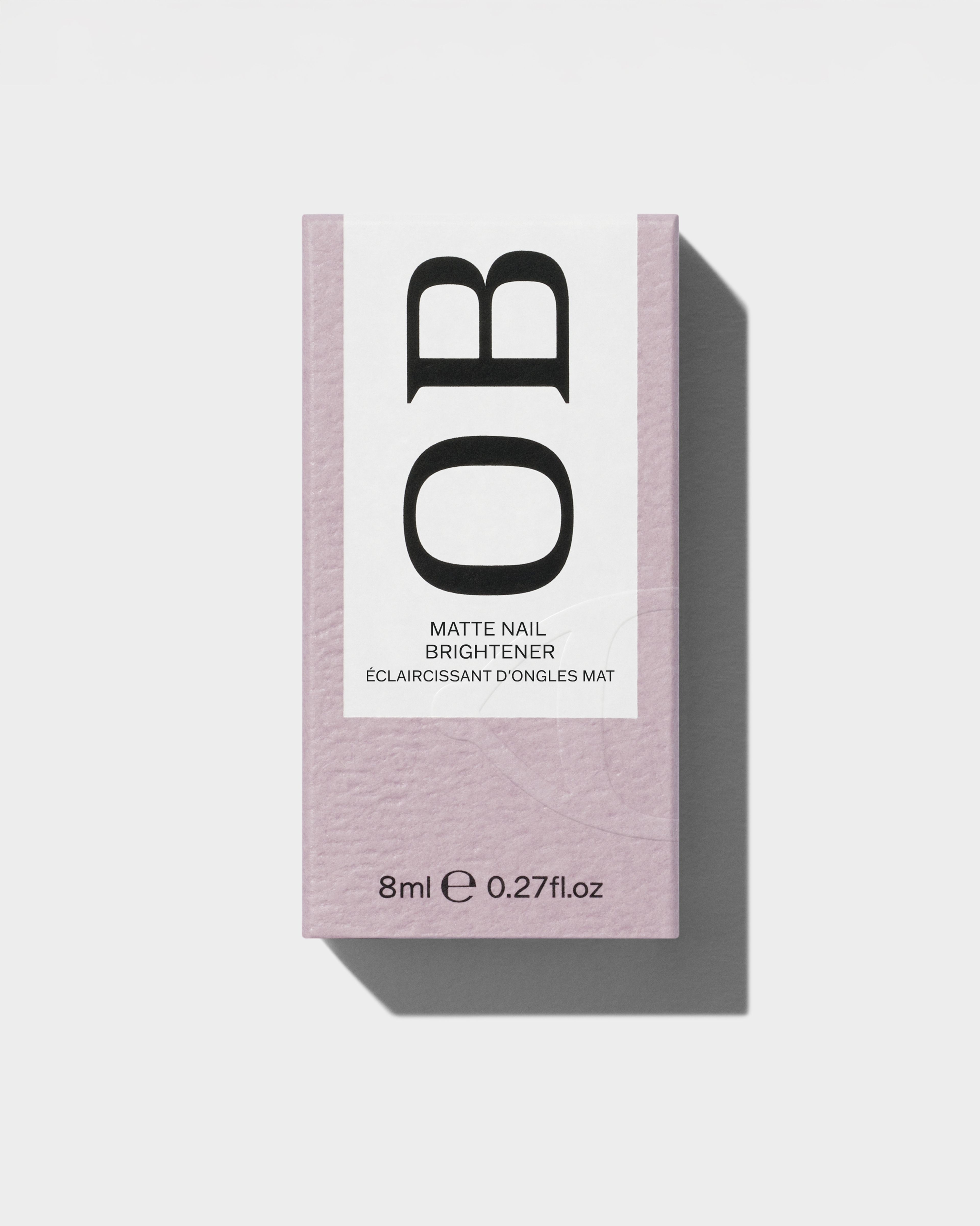 Matte Nail Brightener packaging laying on a grey surface