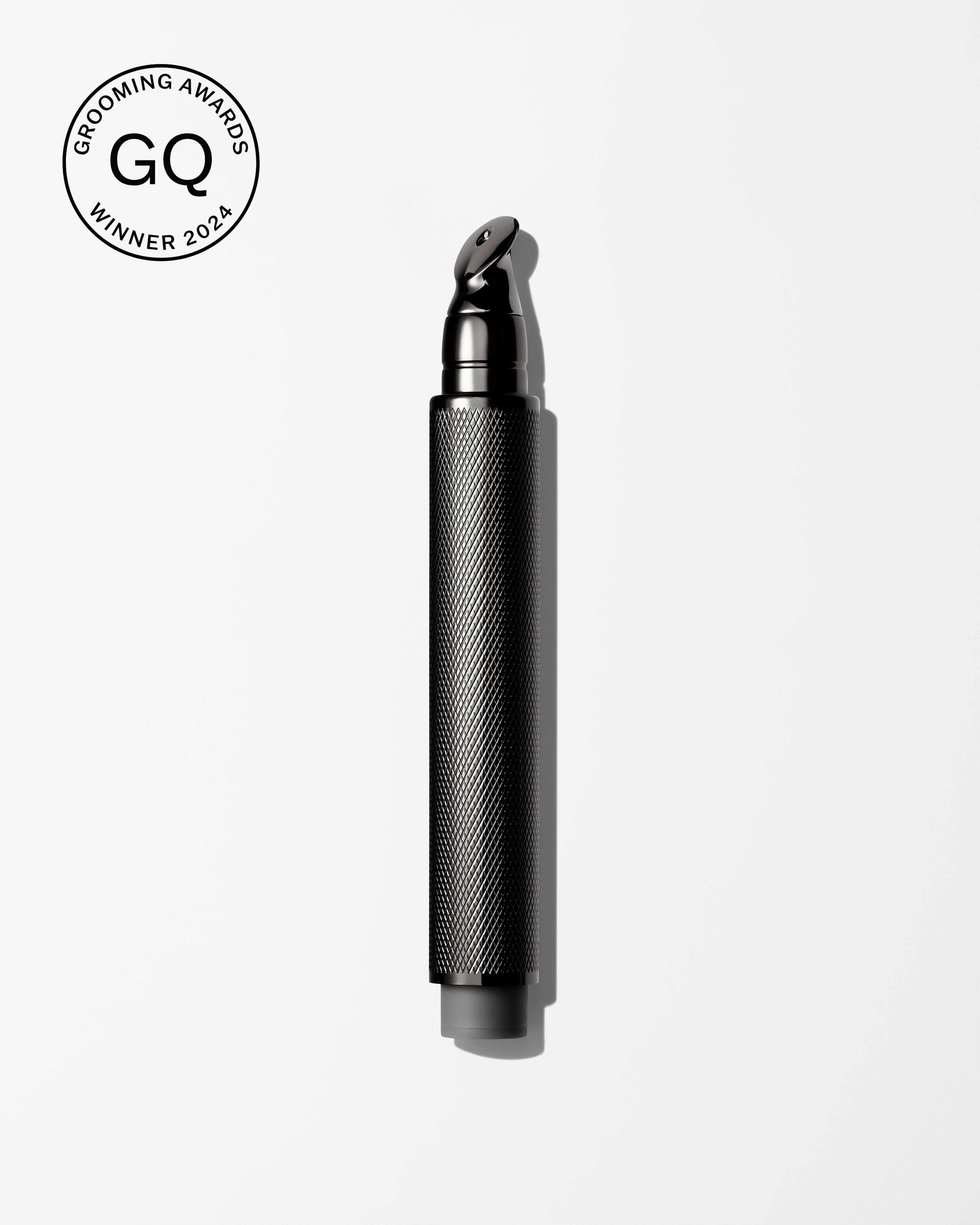 Men's tinted eye cream laying on a grey surface