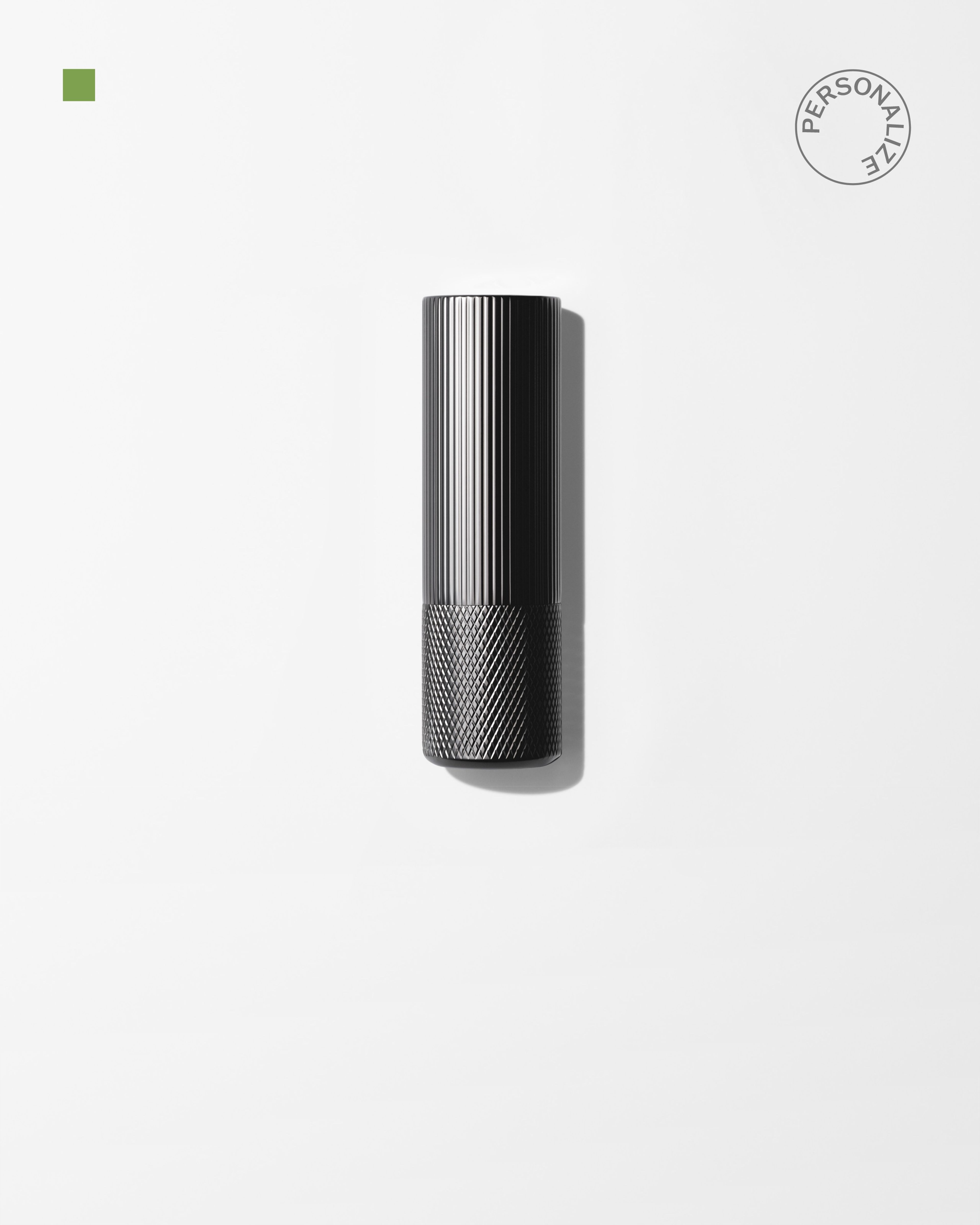 A men's lip balm laying on a grey surface.