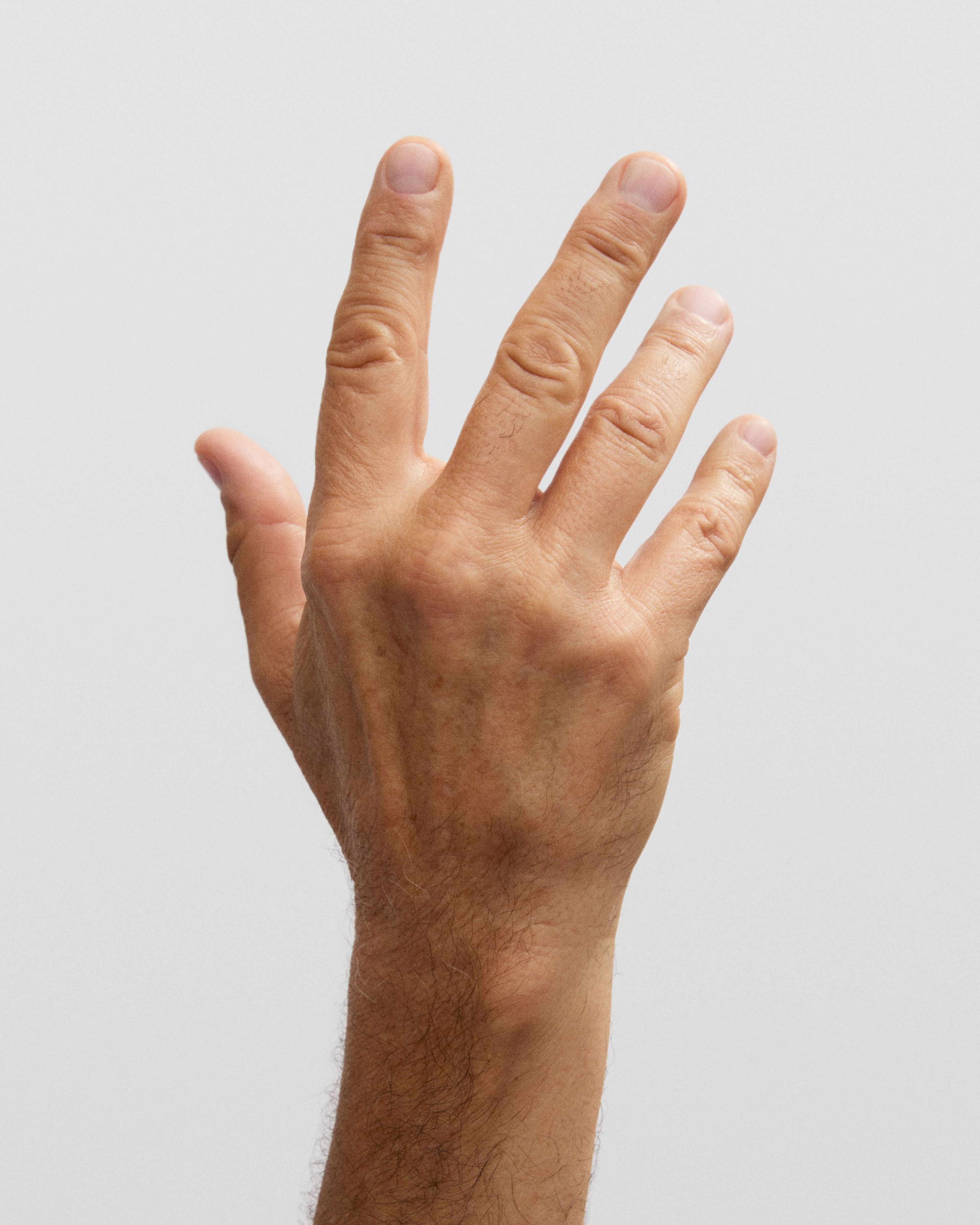 Man holding his hand on his neck with the matte nail brightener applied on his nails
