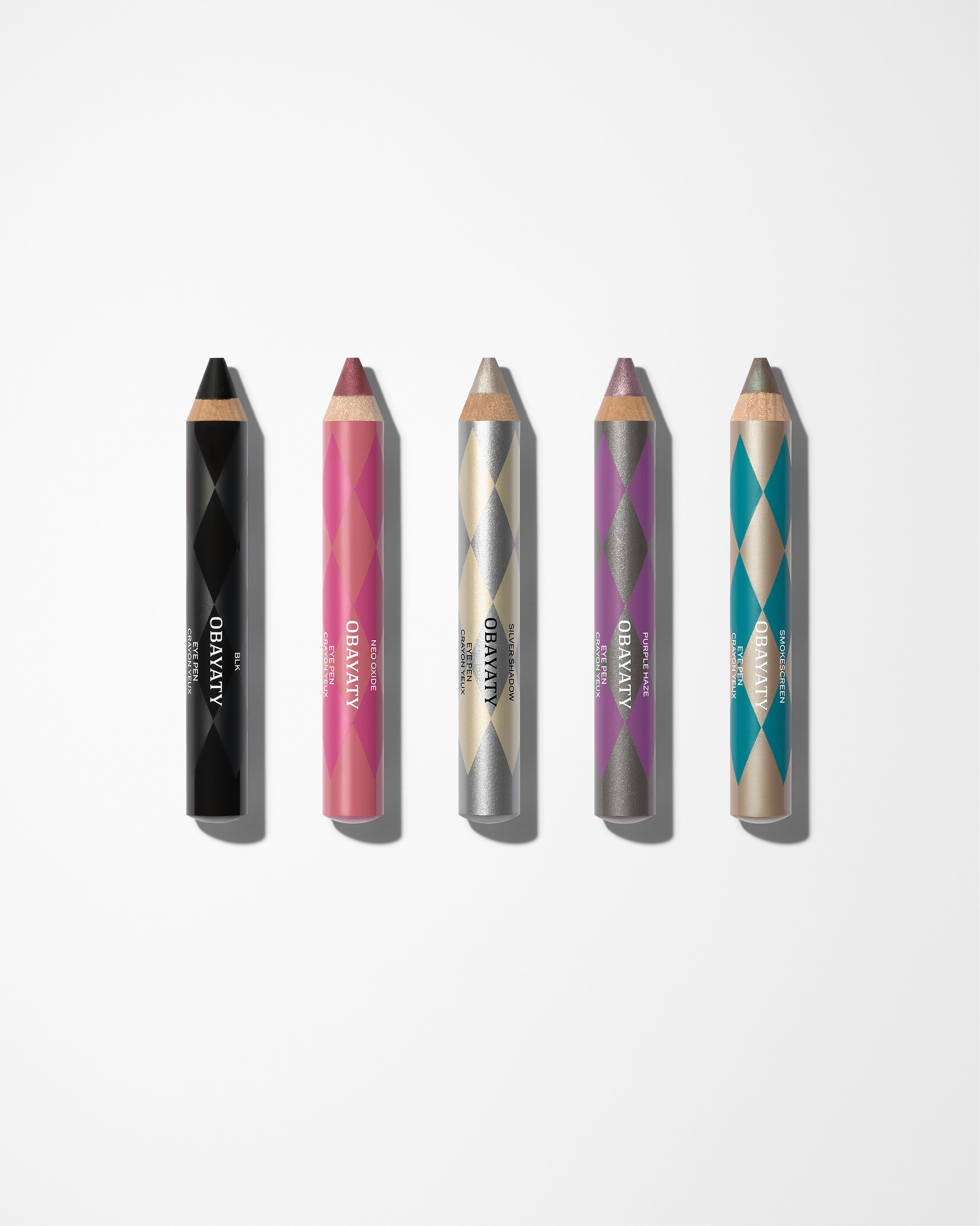 Five eye pens laying on a grey surface