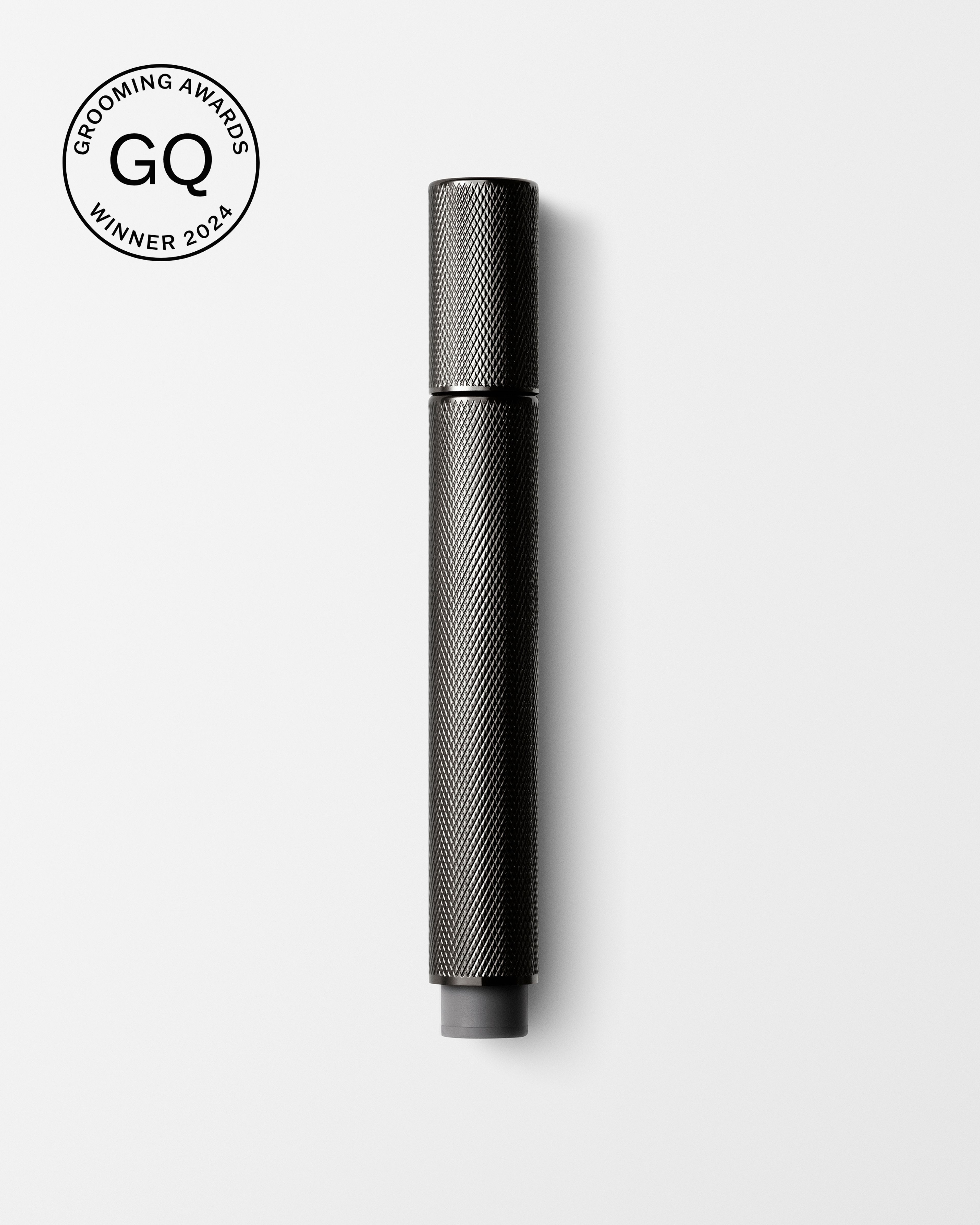 Men's tinted eye cream laying on a grey surface