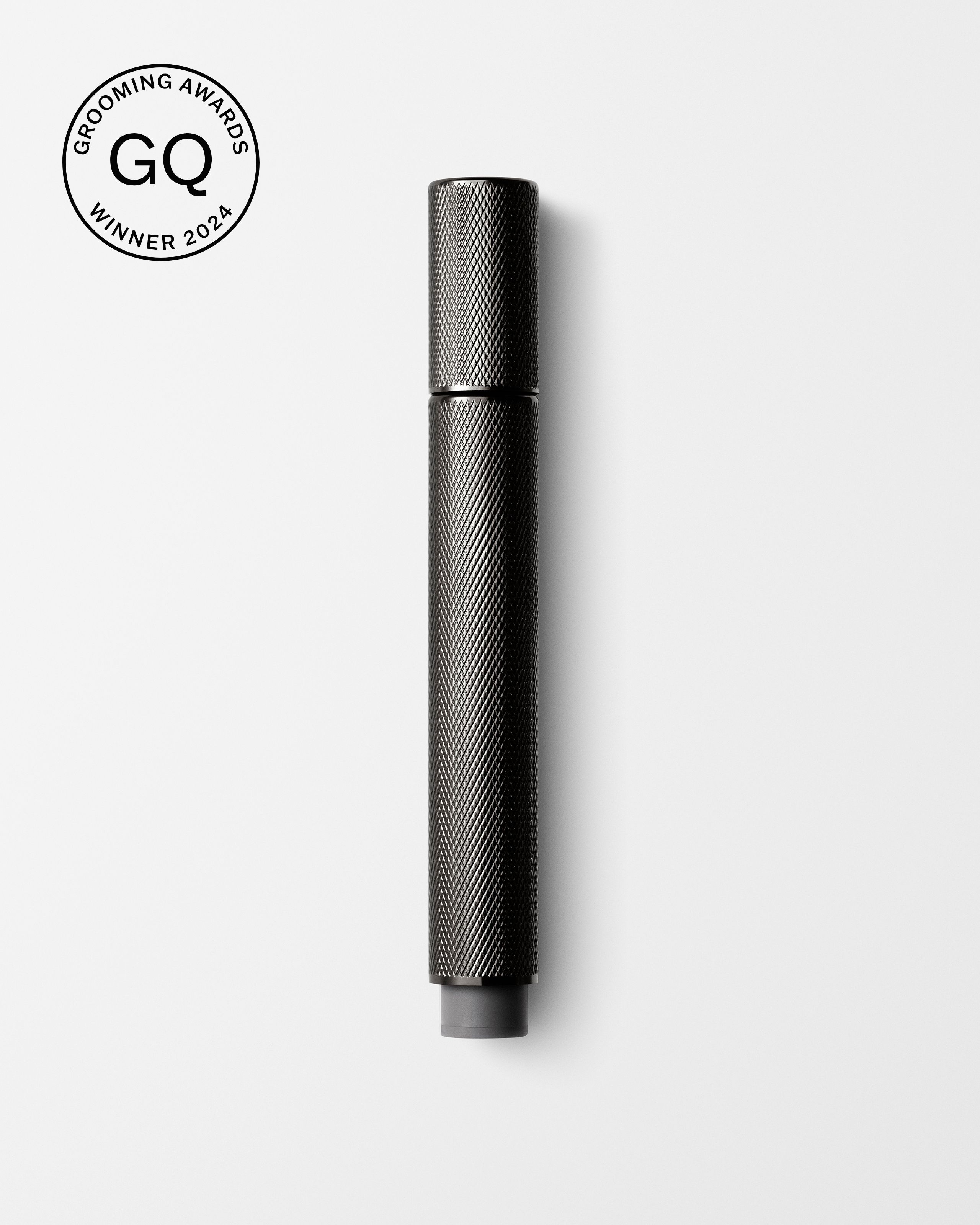 Men's tinted eye cream laying on a grey surface