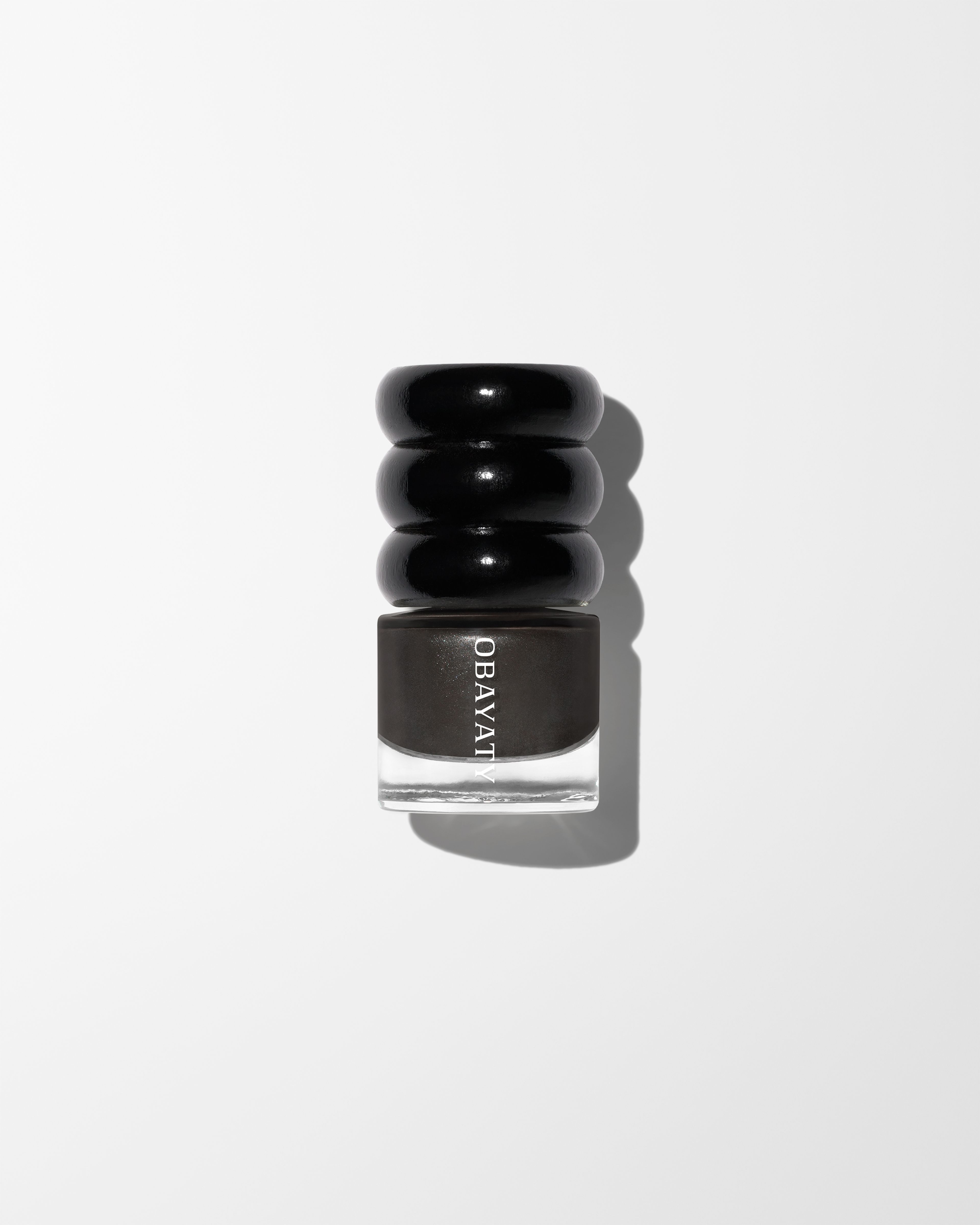 Nail polish Off Black laying on grey surface