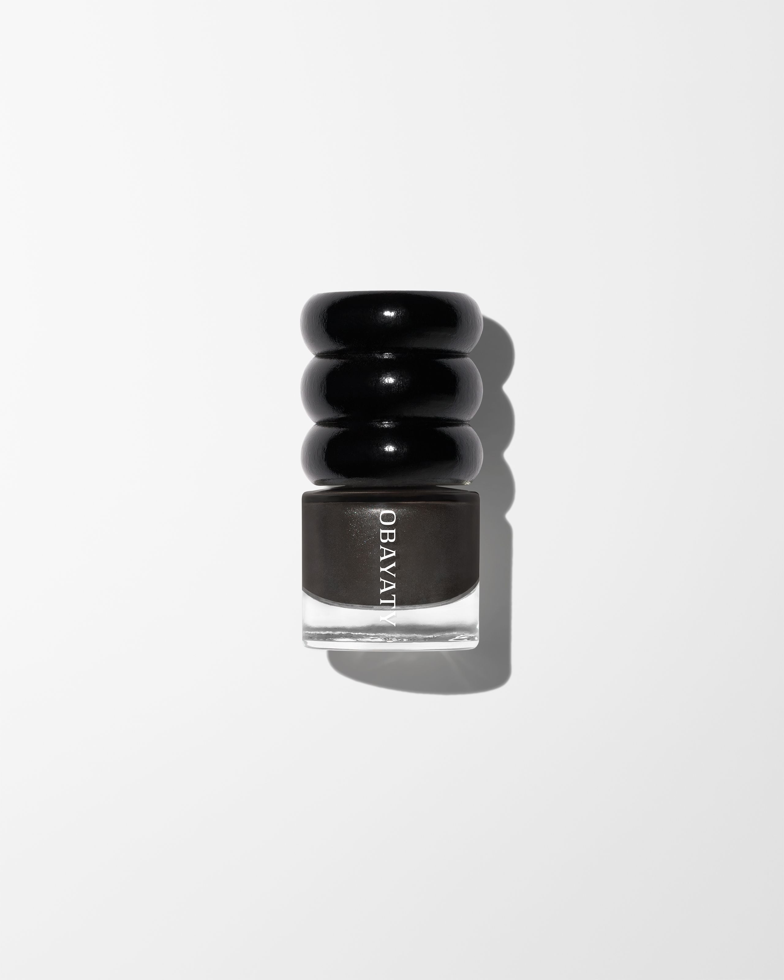 Nail polish Off Black laying on grey surface