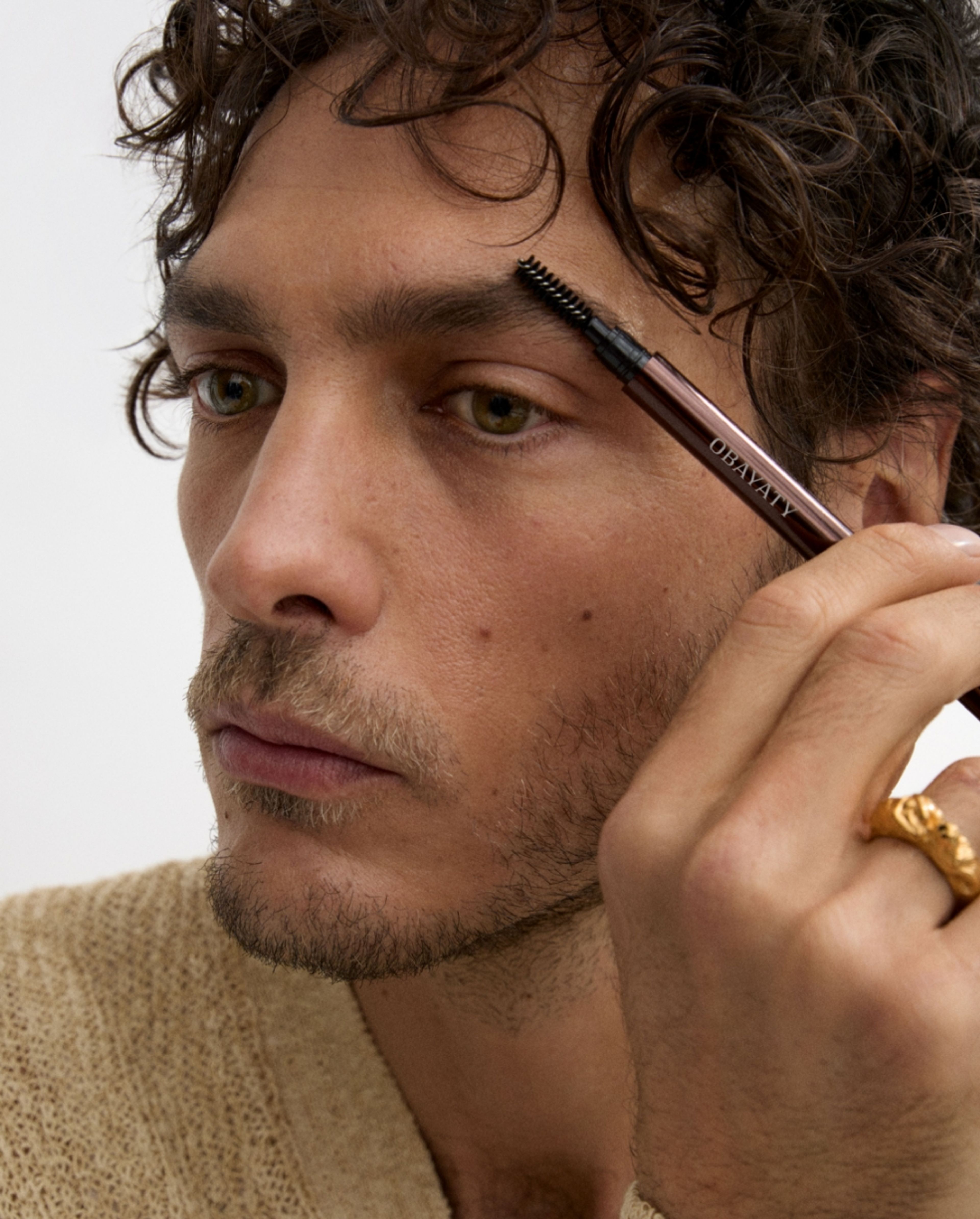 Man brushing his eye brow with brow beard pen