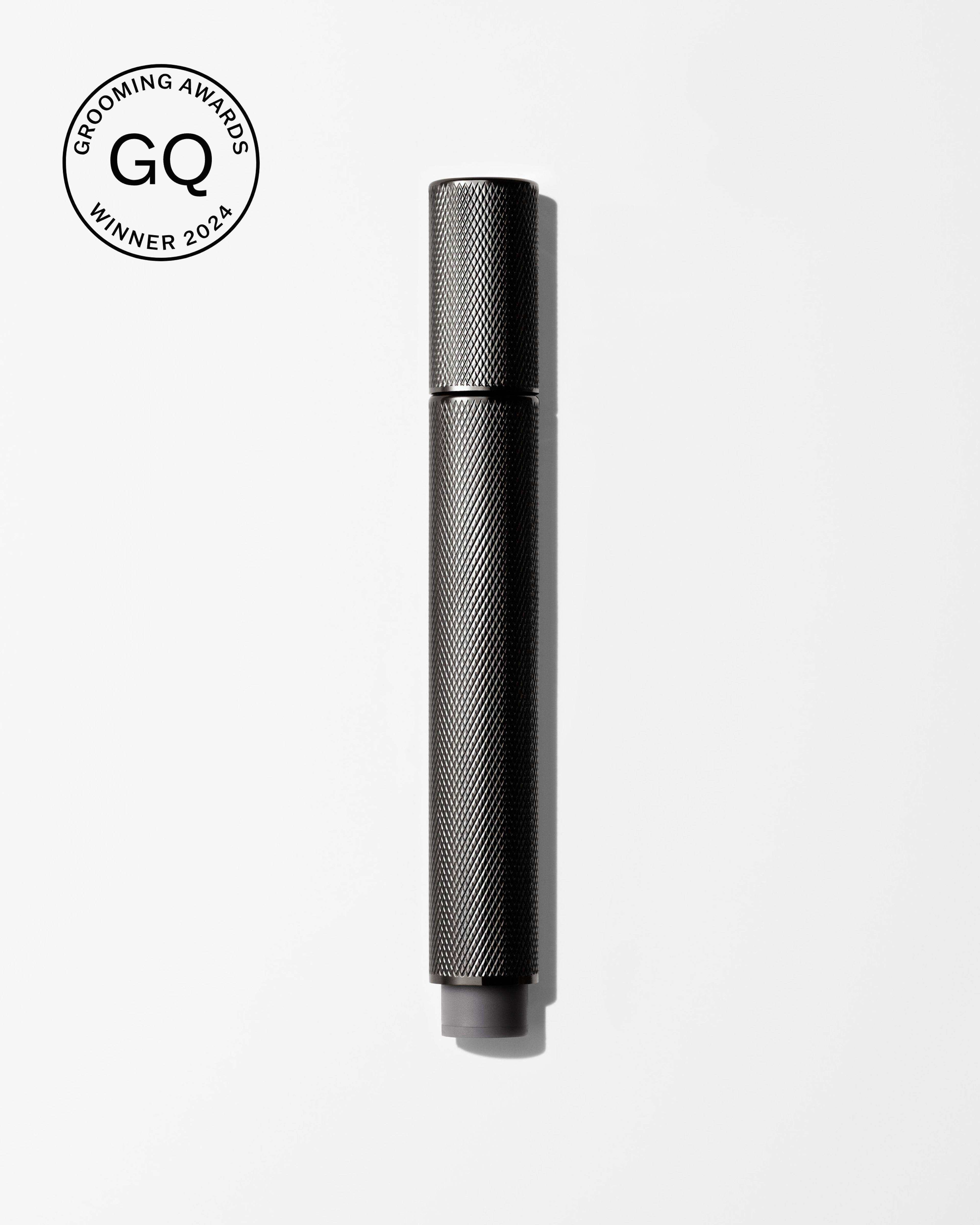 Men's tinted eye cream laying on a grey surface