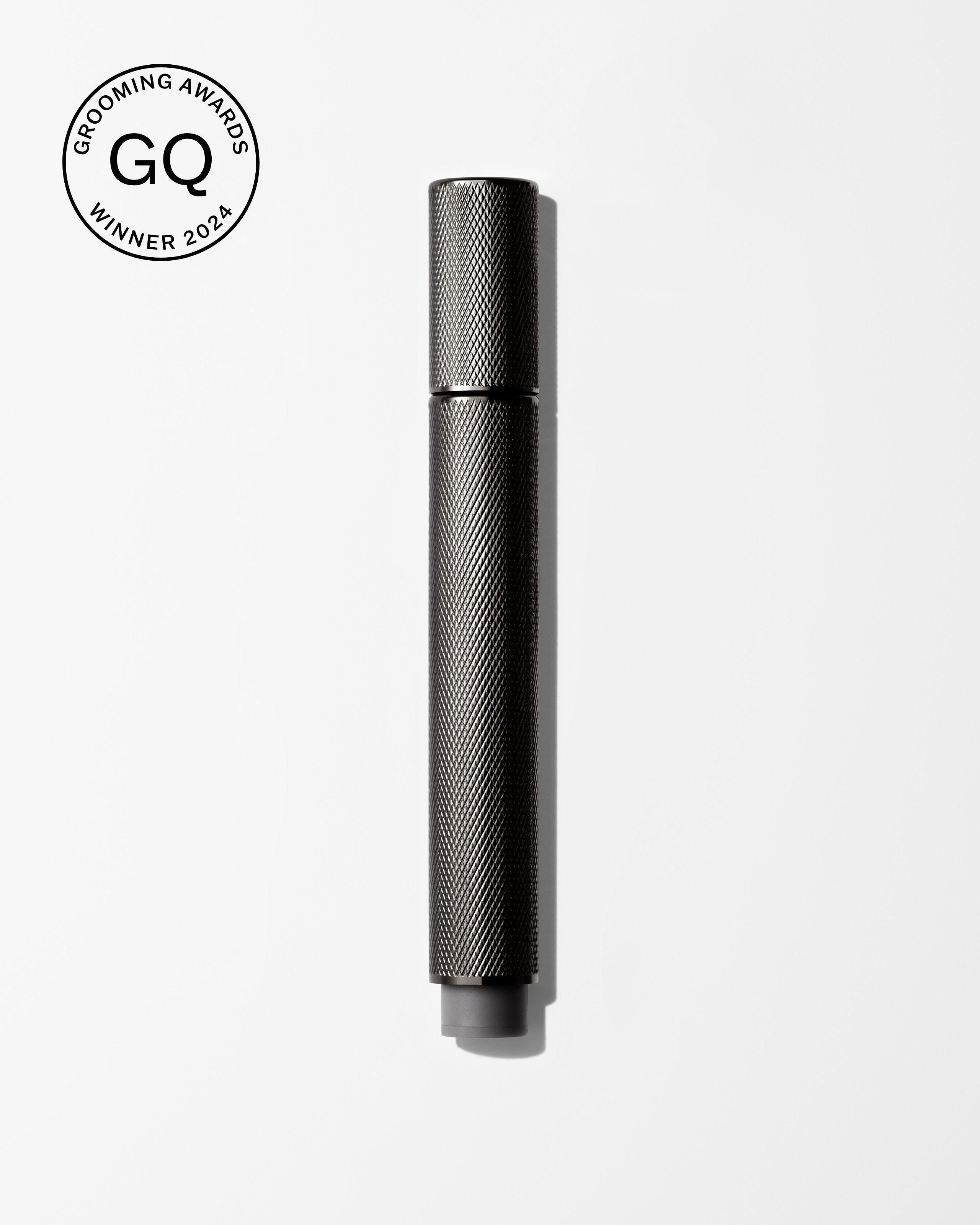 Men's tinted eye cream laying on a grey surface