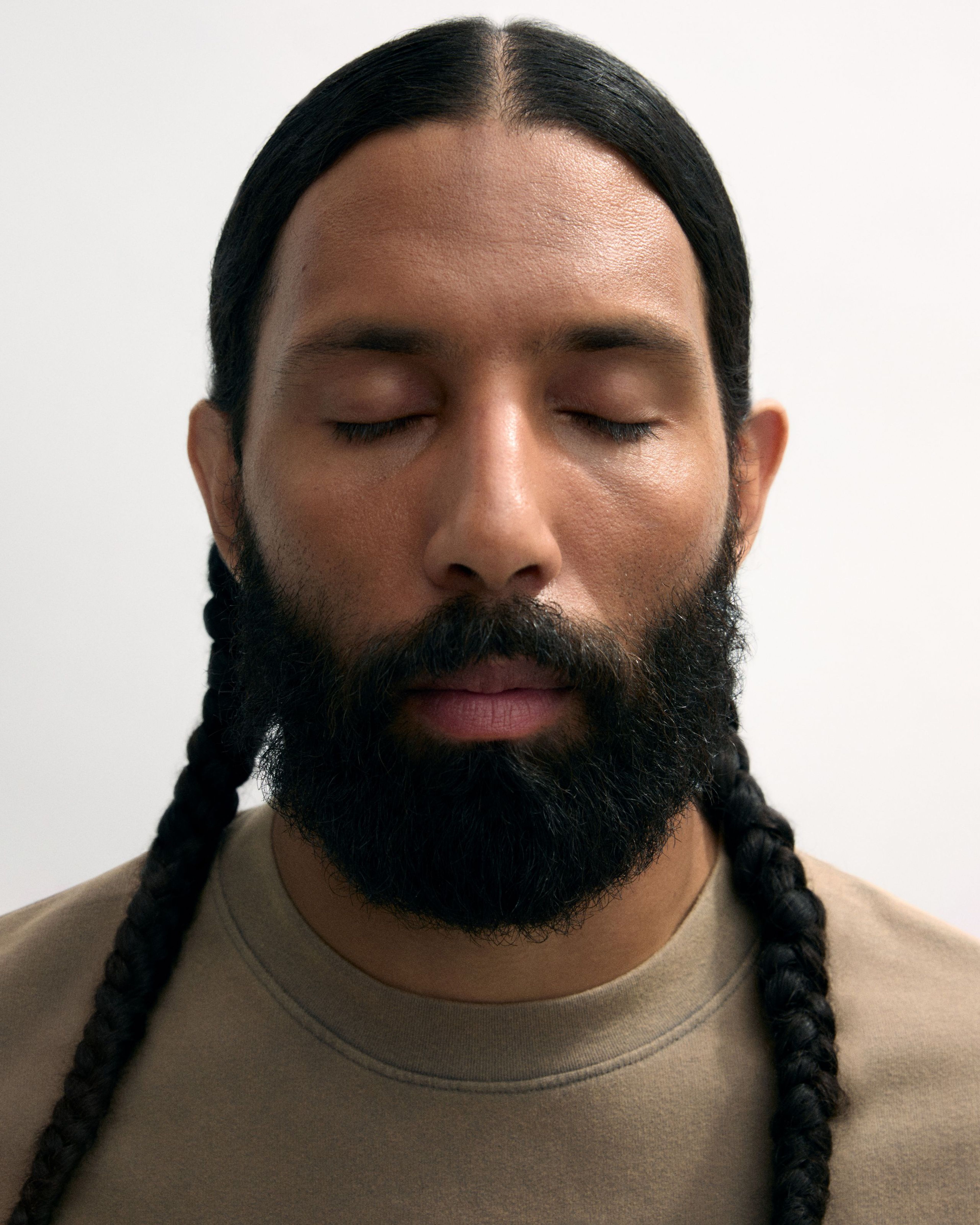 Man with closed eyes with tinted moisturizer applies