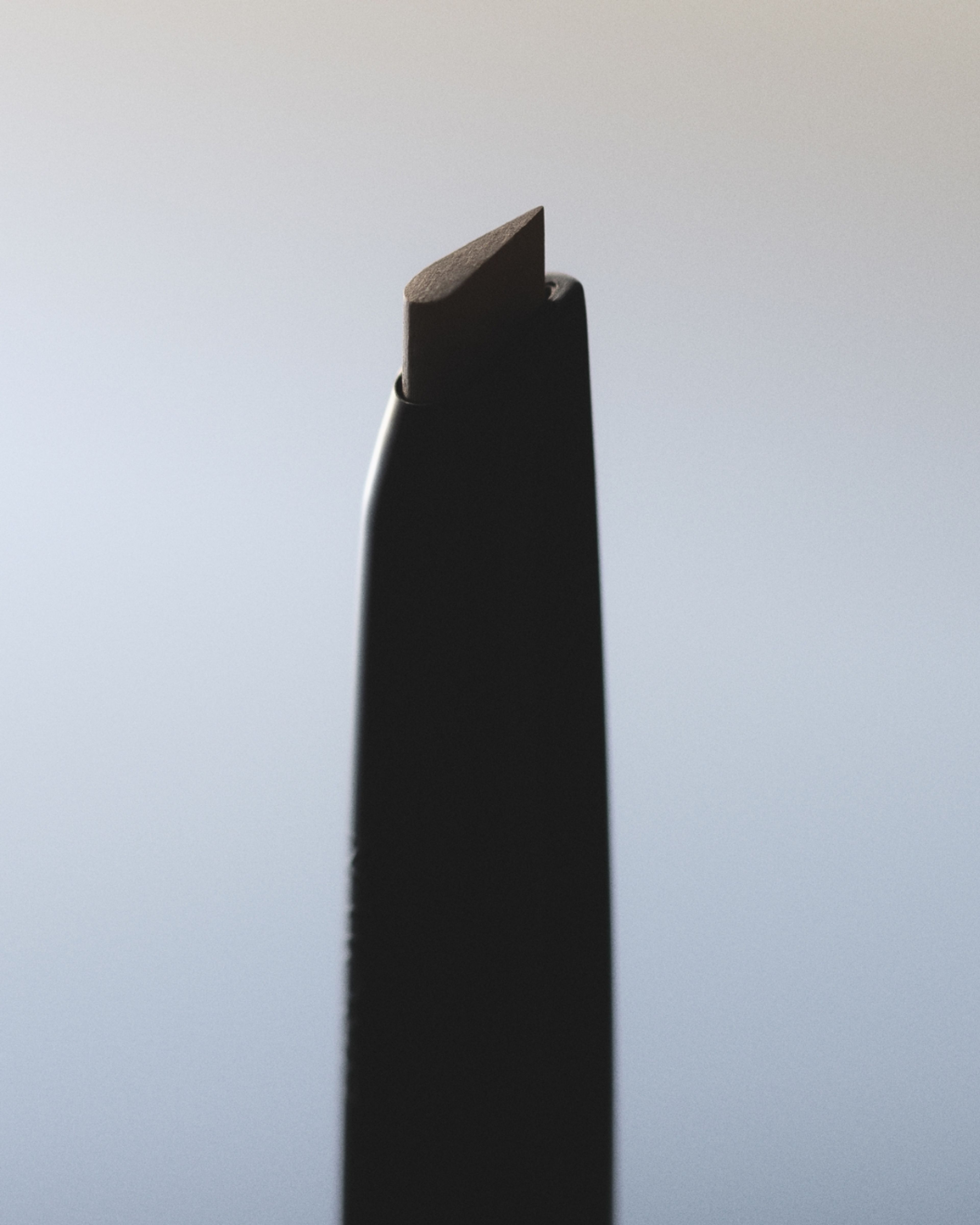 Brow Beard Pen laying on grey background