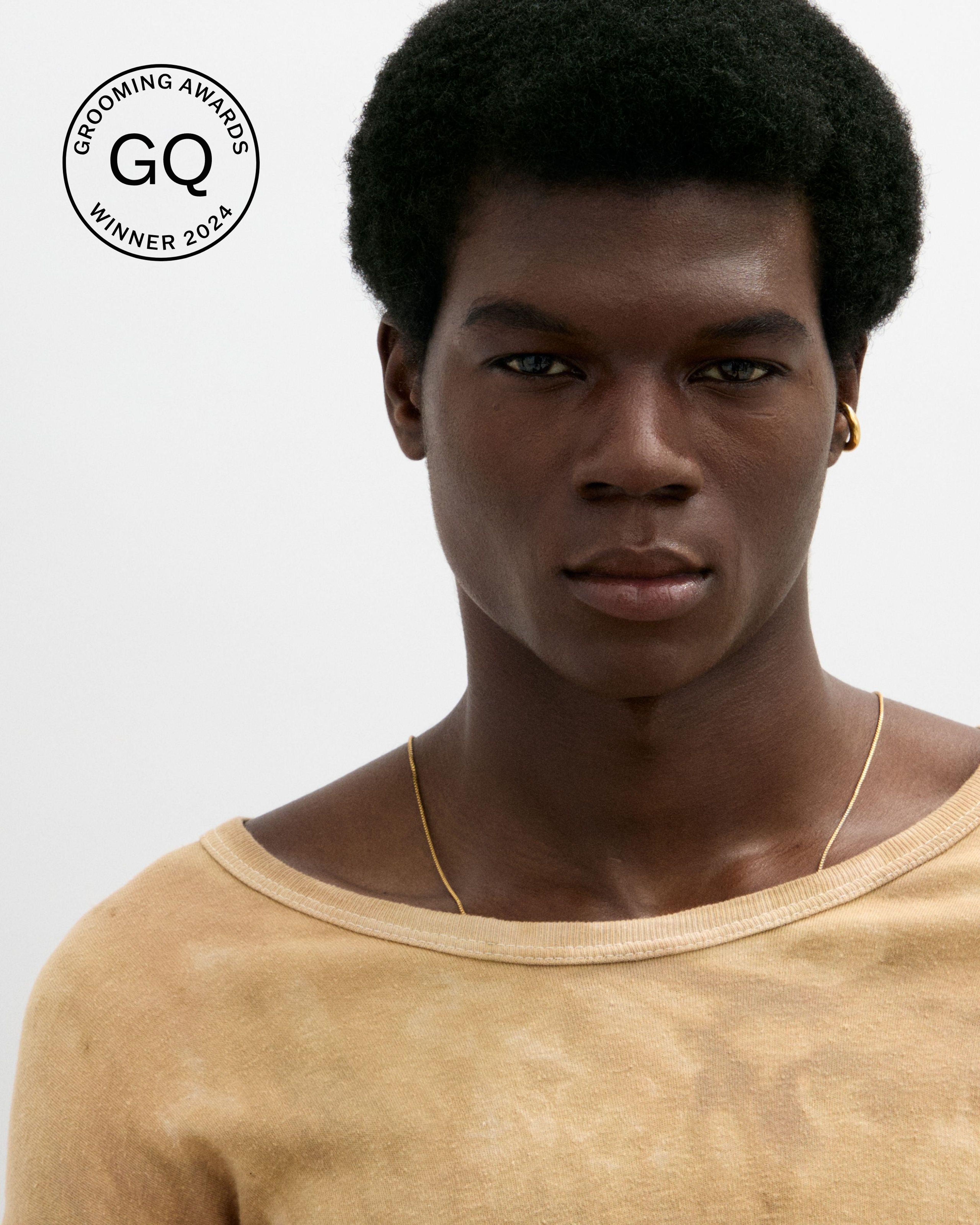 Men's tinted eye cream laying on a grey surface