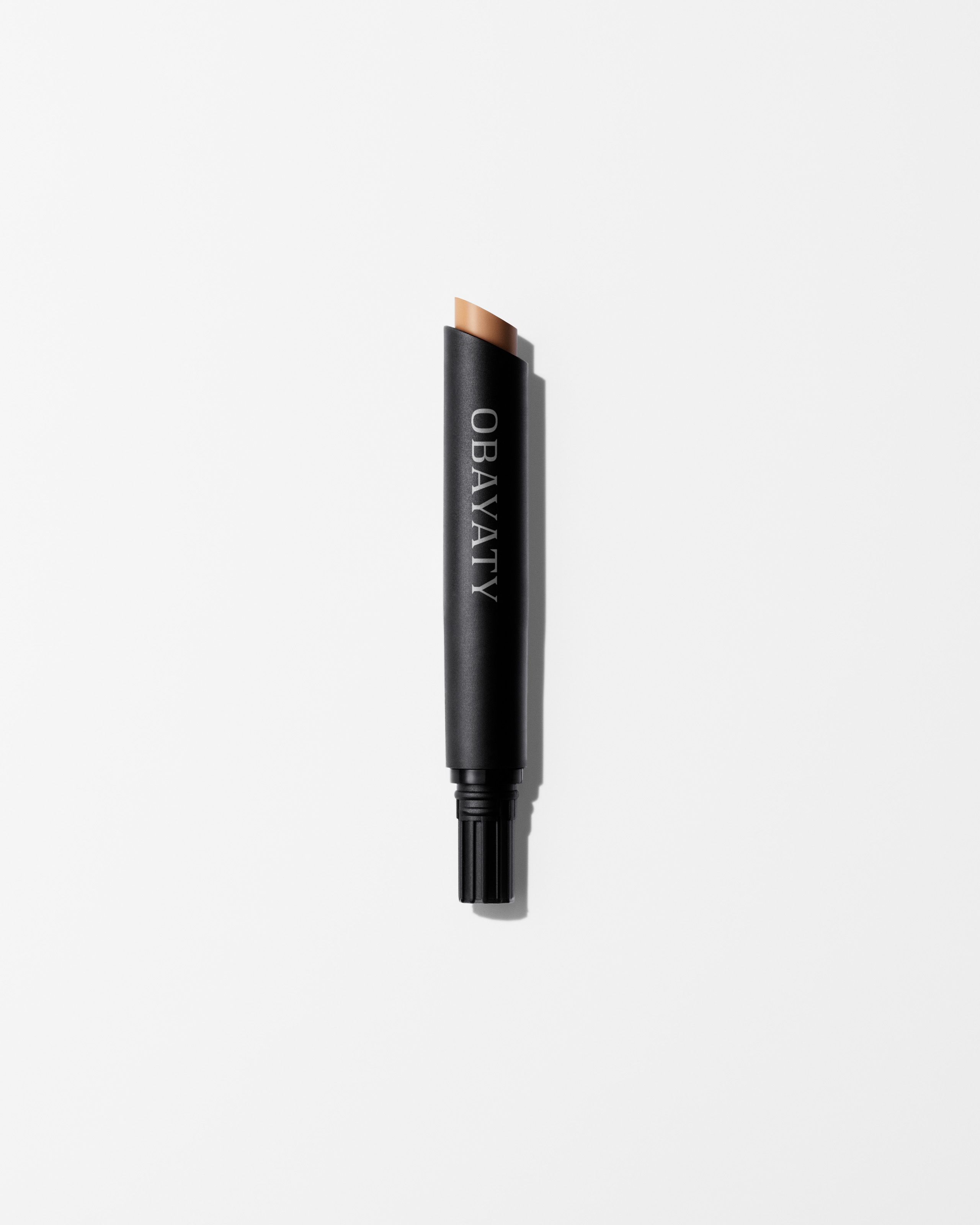 Mens concealer refill laying on a grey surface