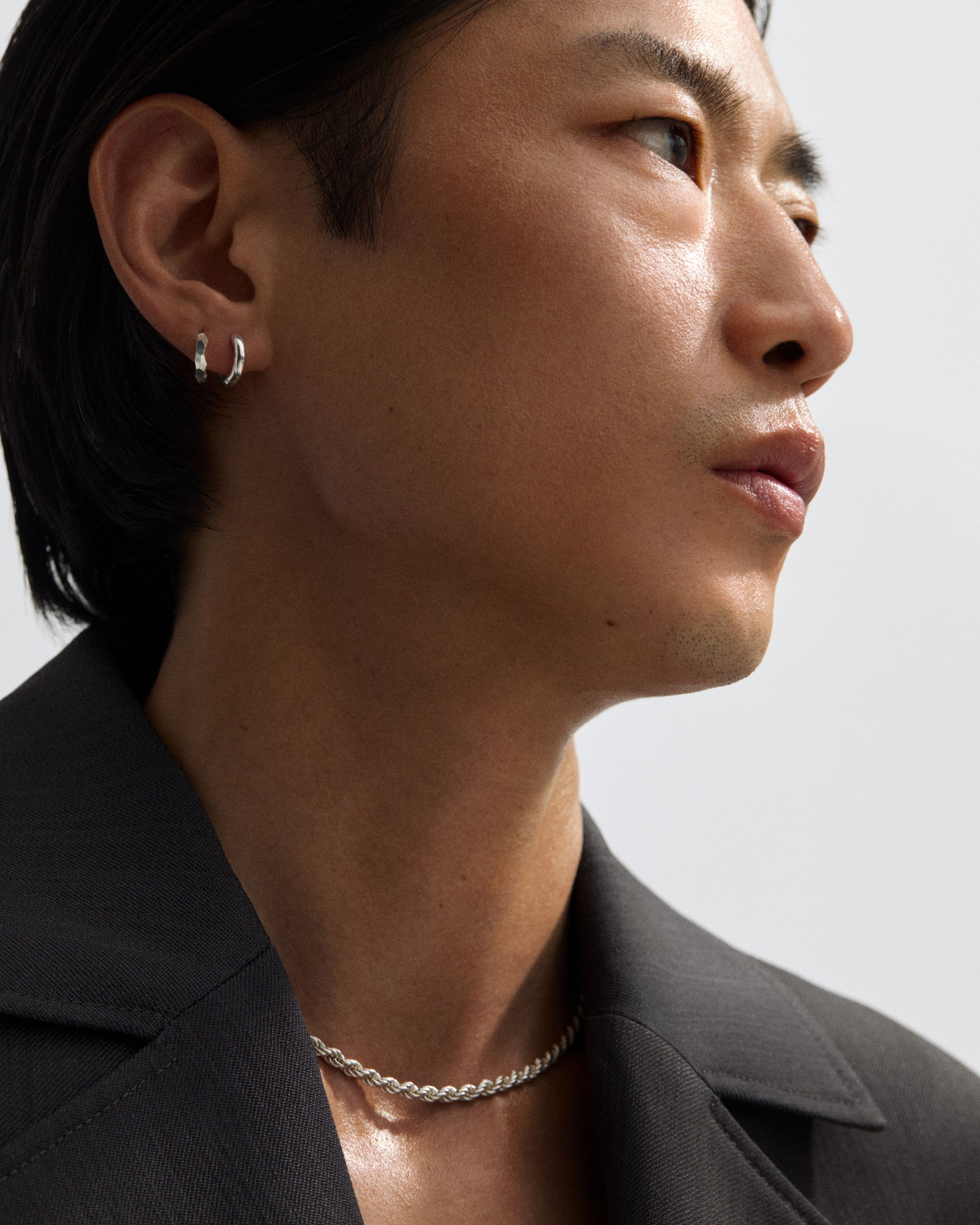 Man looking to the right in front of a grey background