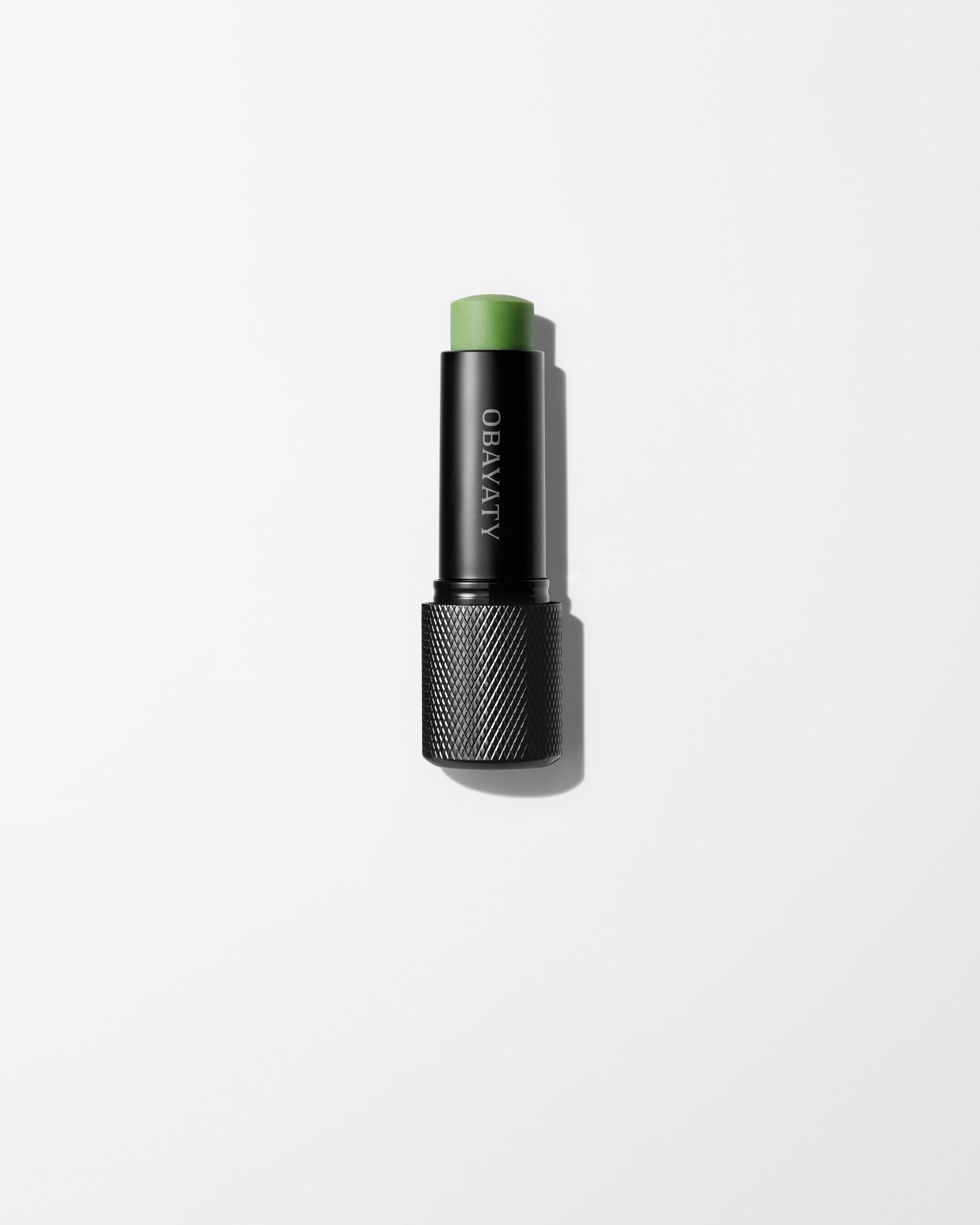 A men's lip balm laying on a grey surface.