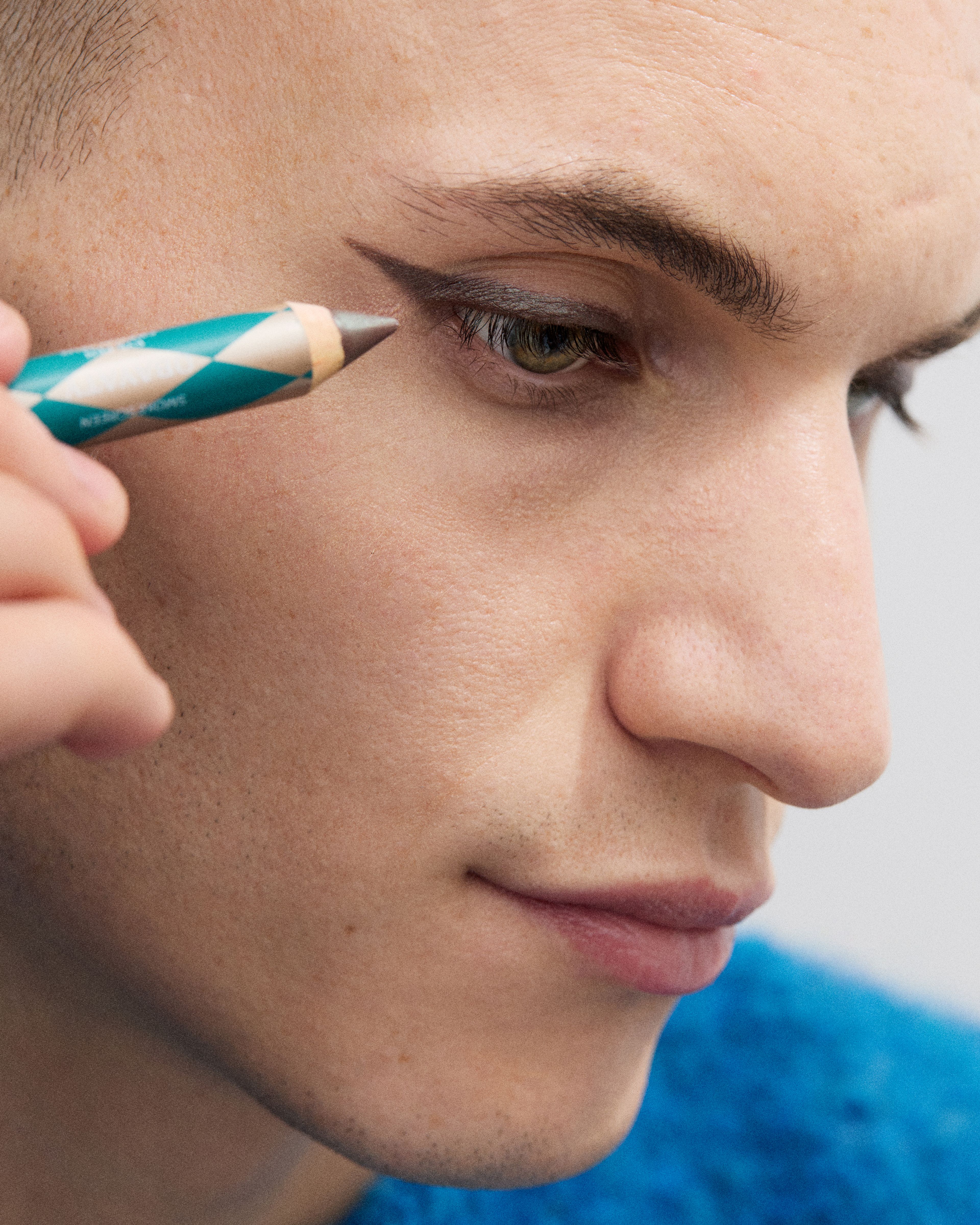 Man applying an eye pen