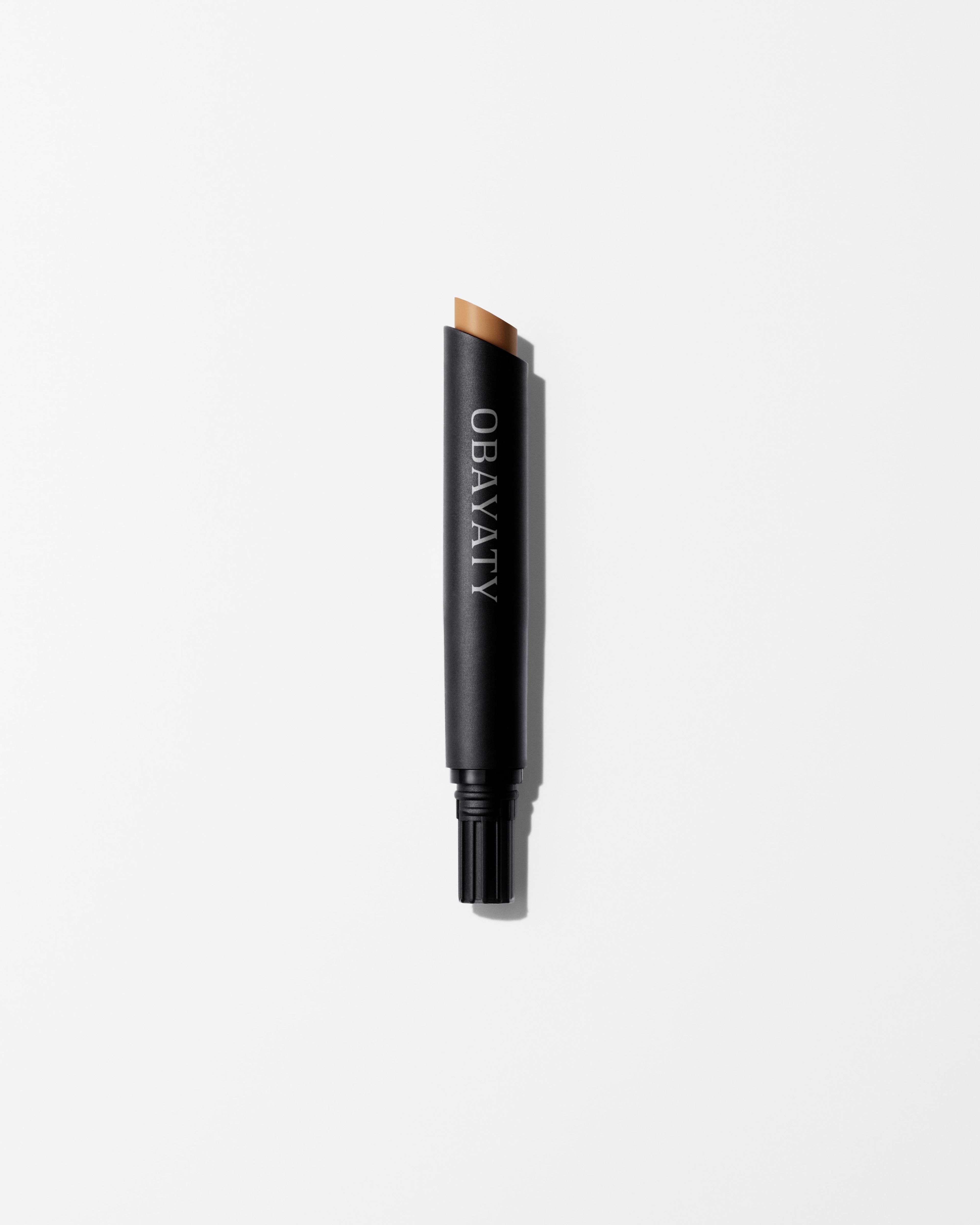Concealer refill in the shade light laying on grey surface