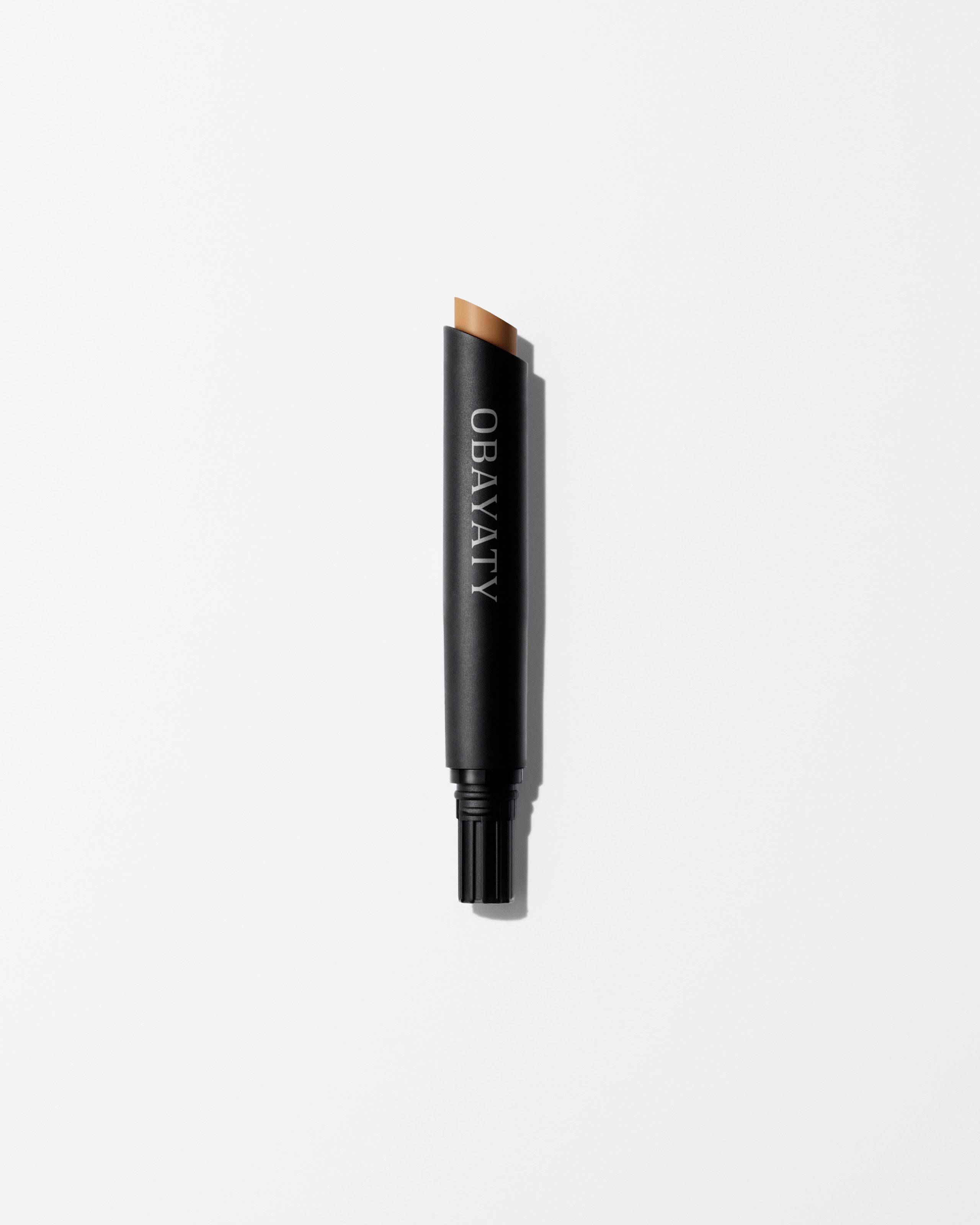 Concealer refill in the shade light laying on grey surface