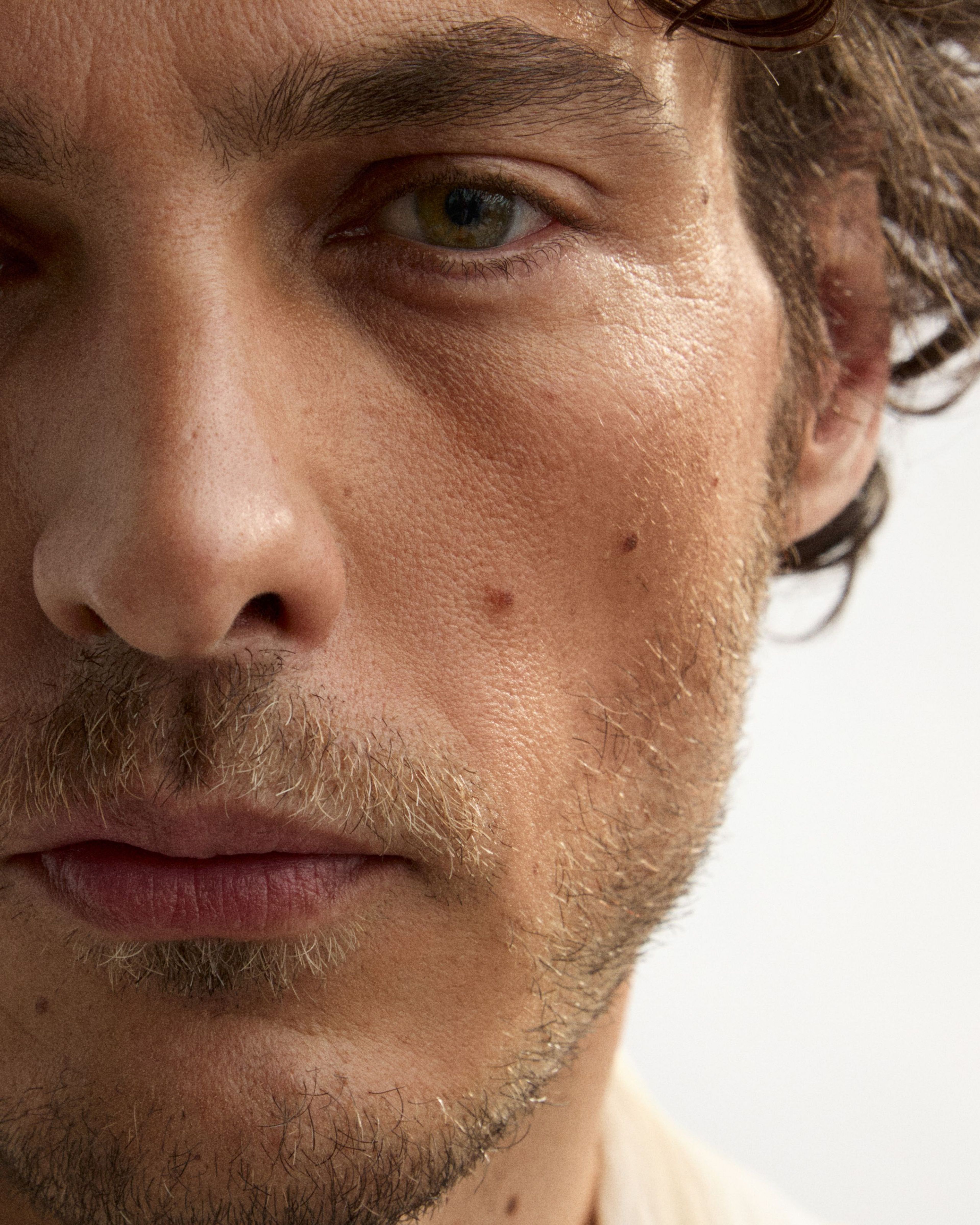 Man looking into the camera with bronzer applied on his cheek