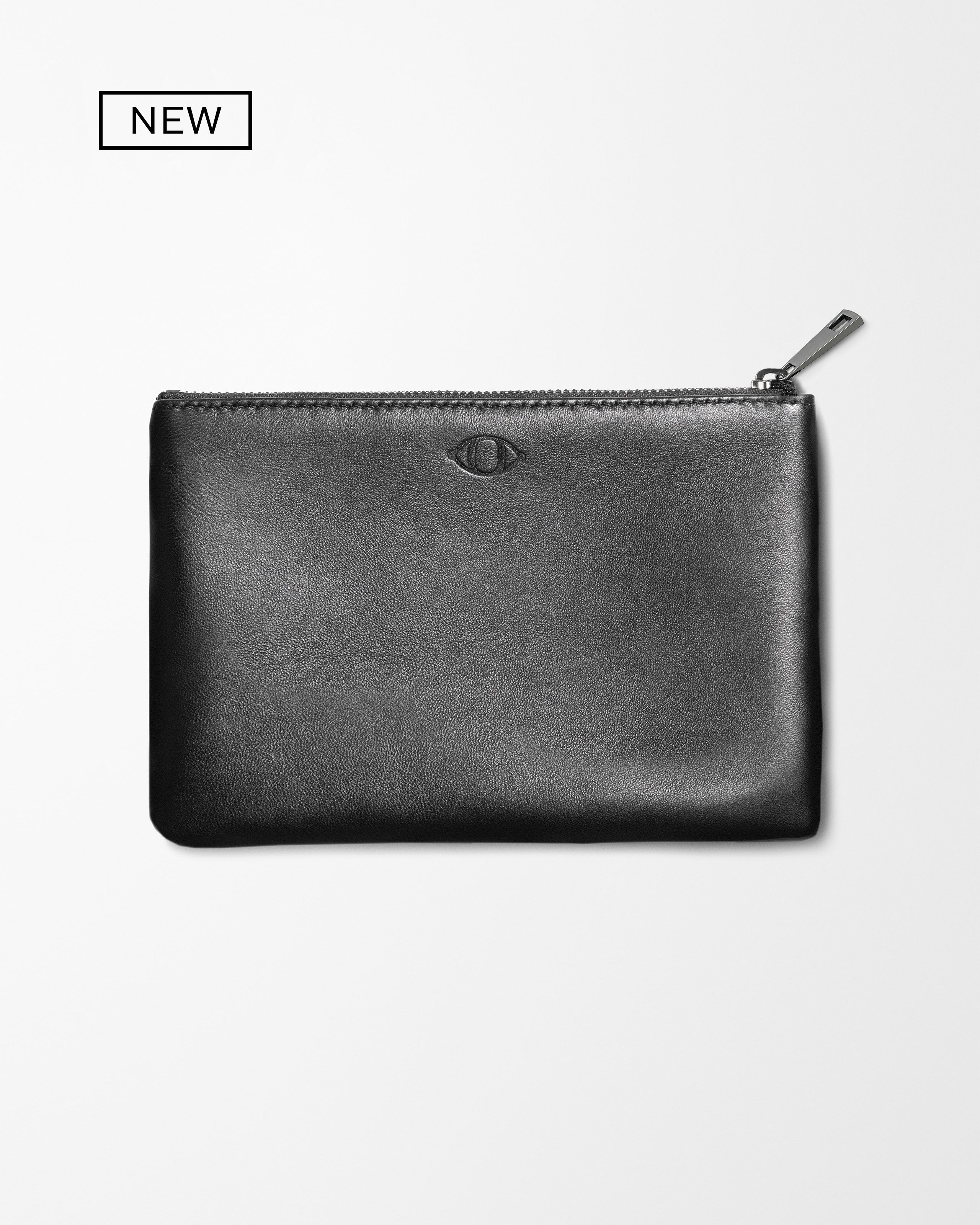 Black leather pouch laying on grey background