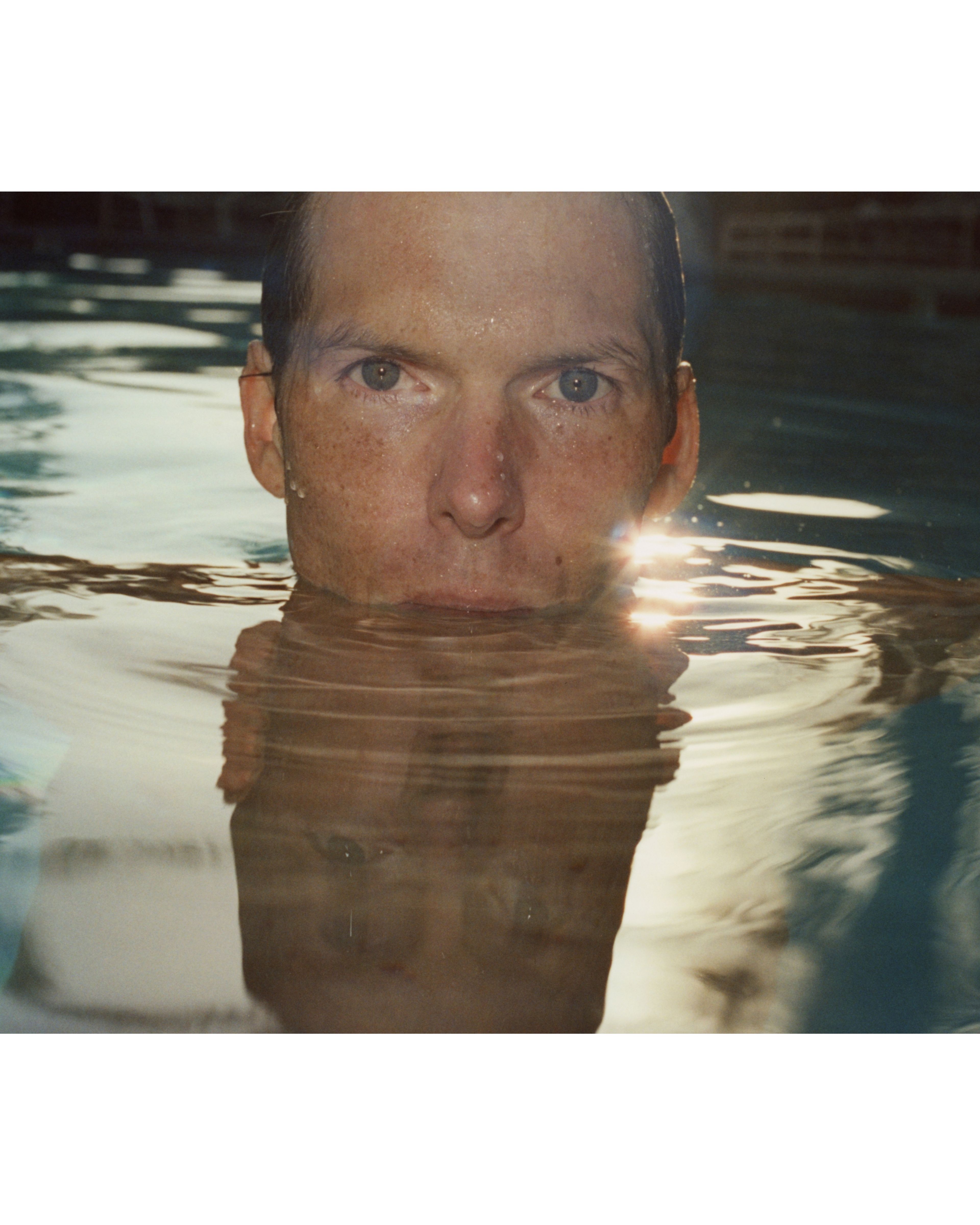 Man swimming at sunset