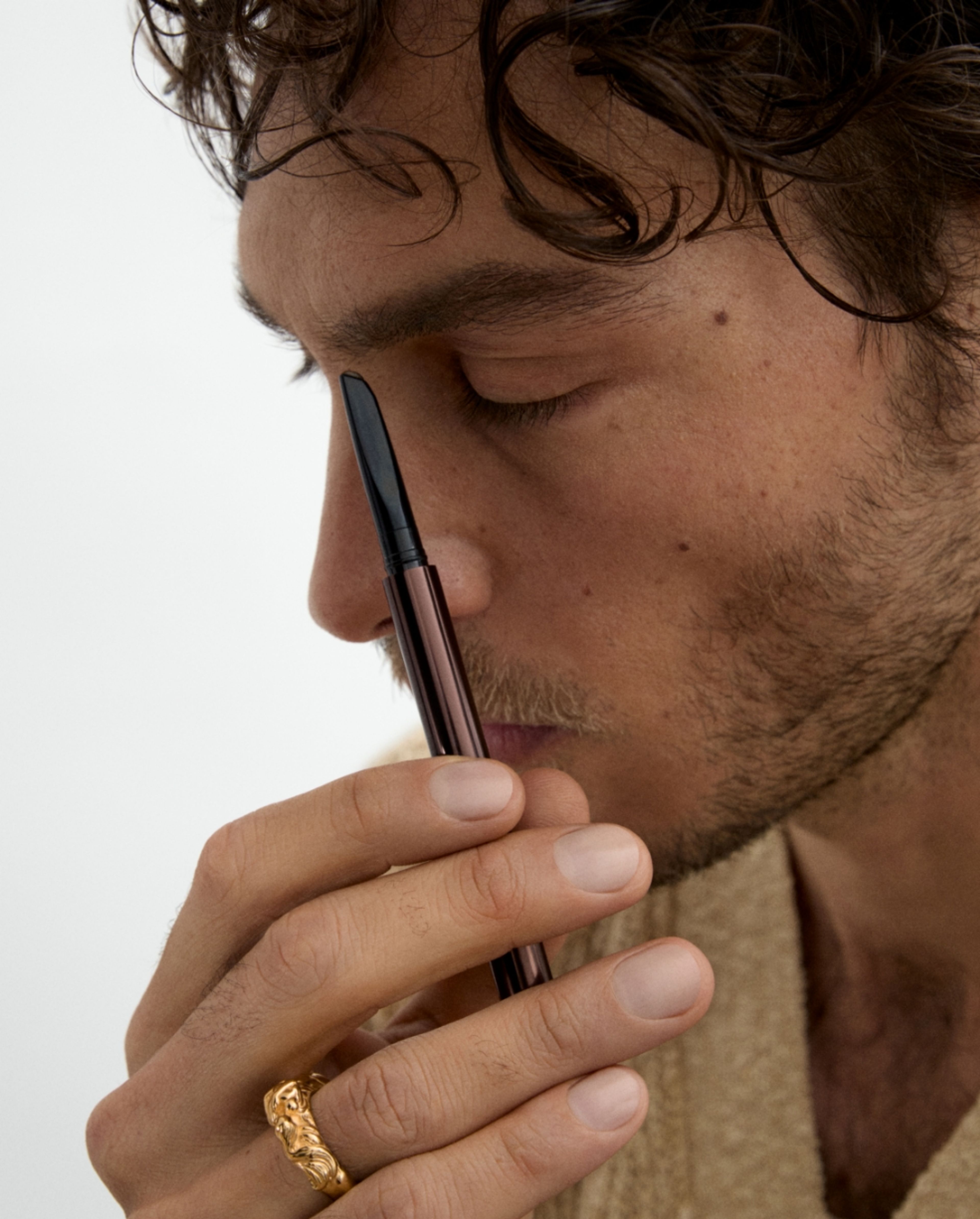 Man painting his eye brow with brow beard pen