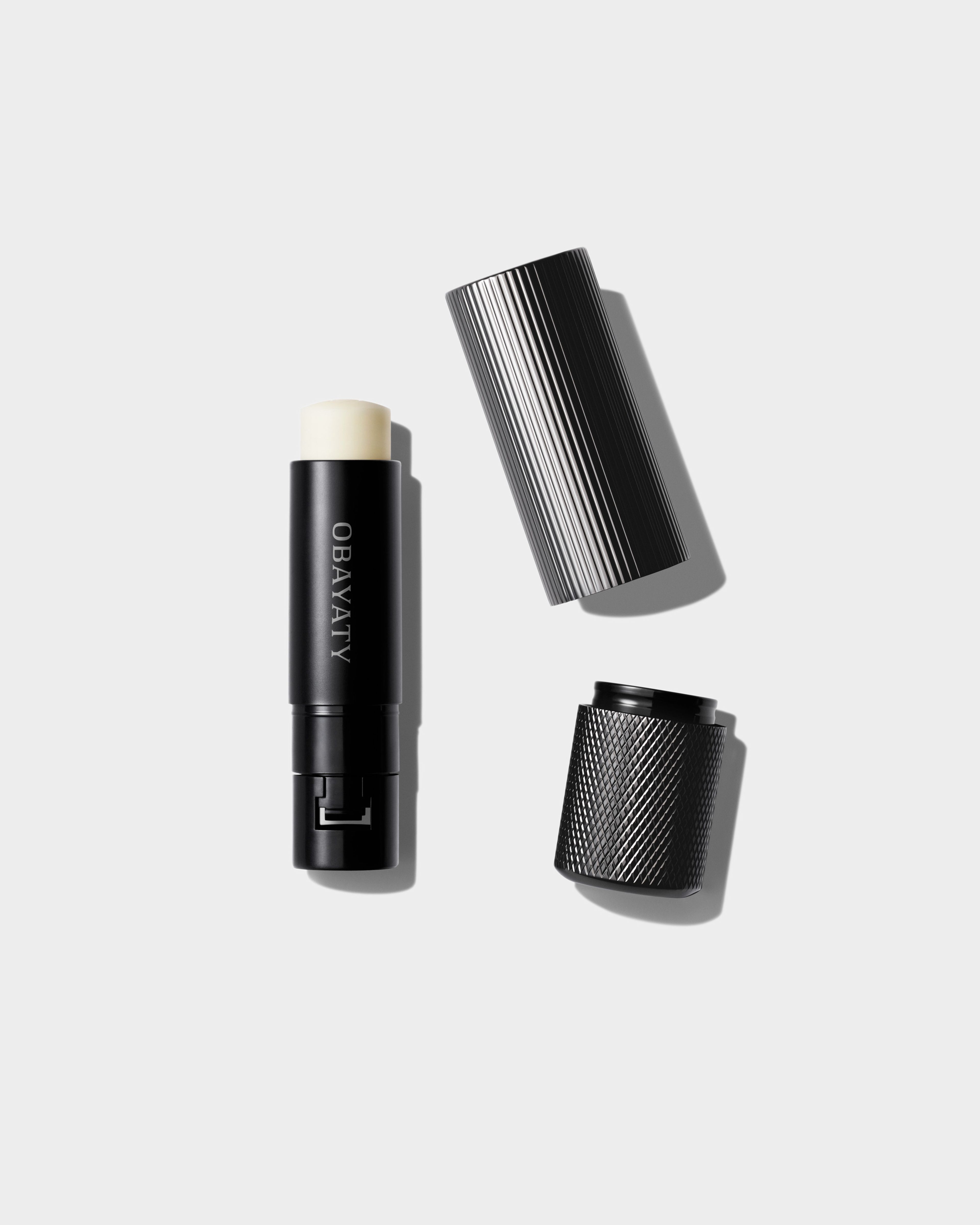 Soothing Lip Balm case and refill laying on a grey background