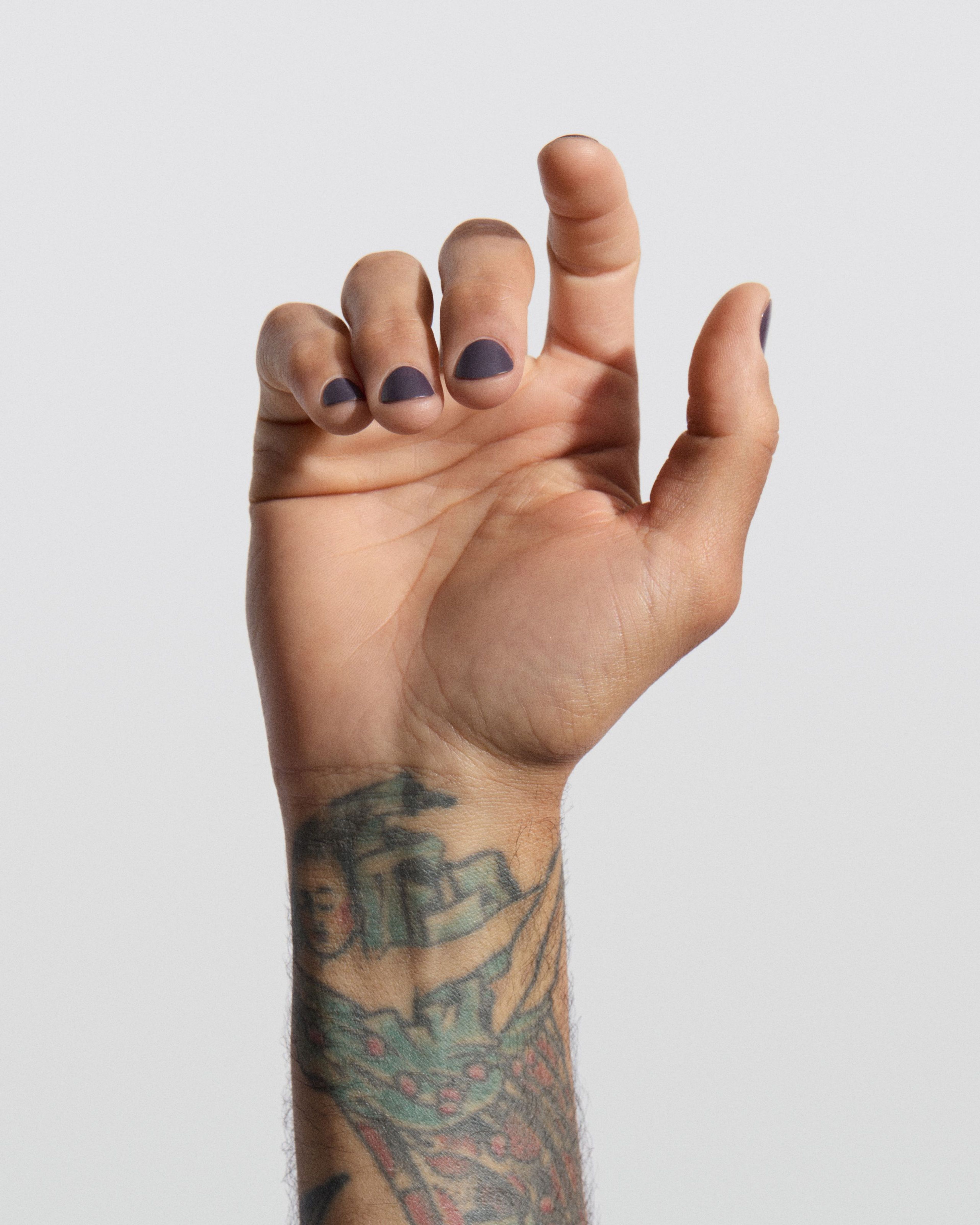 Man holding up his hand with nail polish Violet Dusk applied