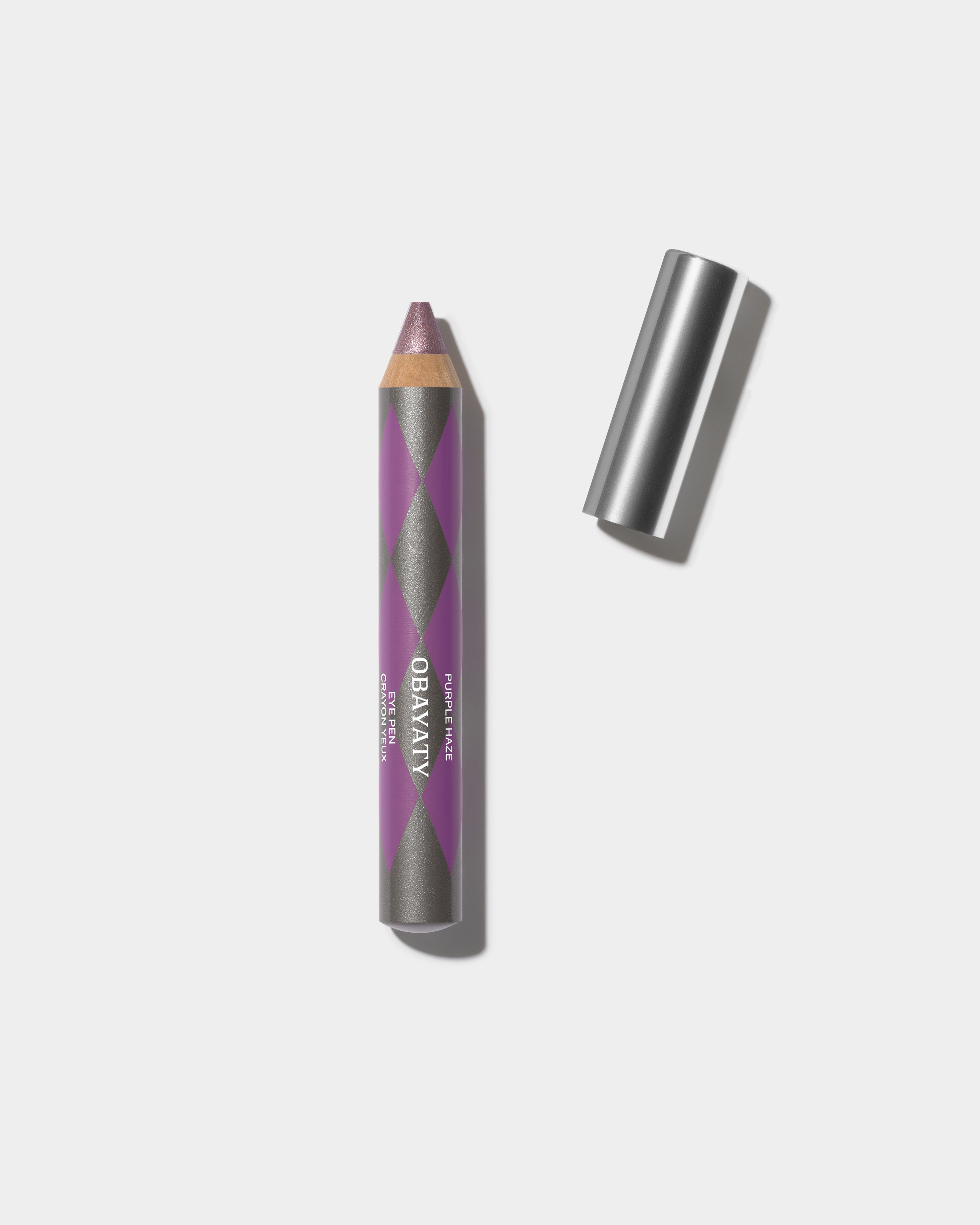 Eye Pen Purple Haze and silver cap laying on a grey surface