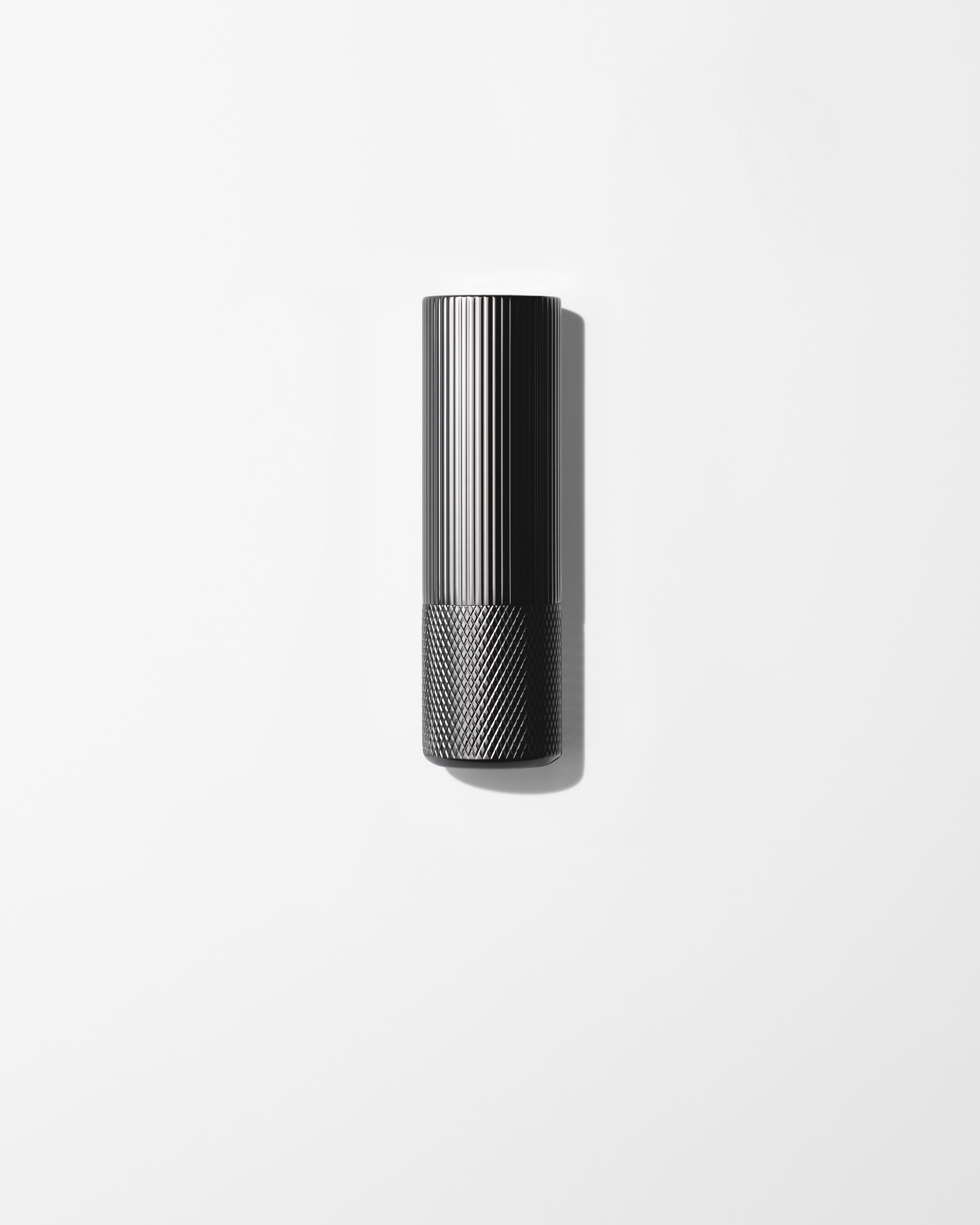 Anti-rouge lip balm laying on a grey surface