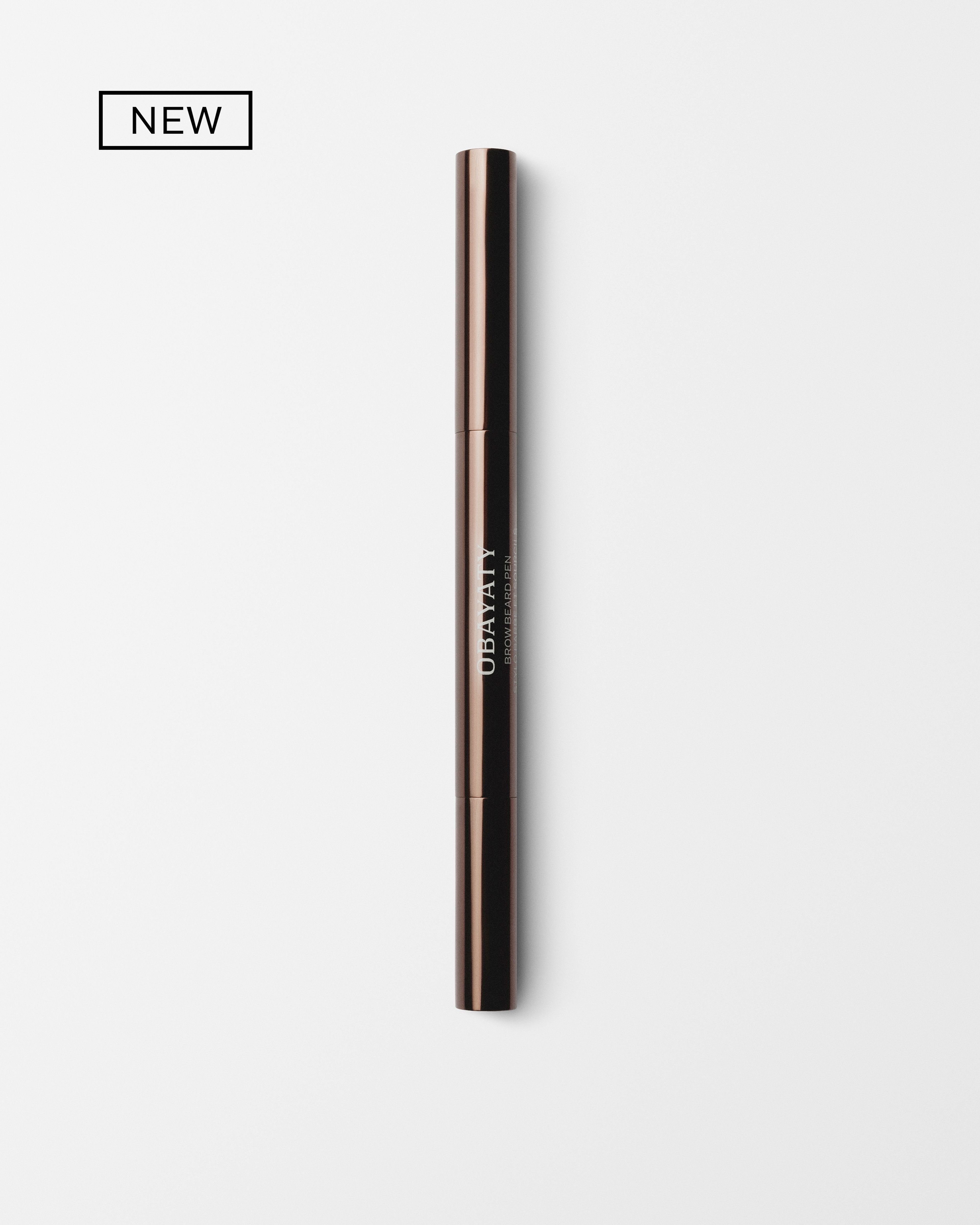 Men's brow beard pen laying on a grey surface