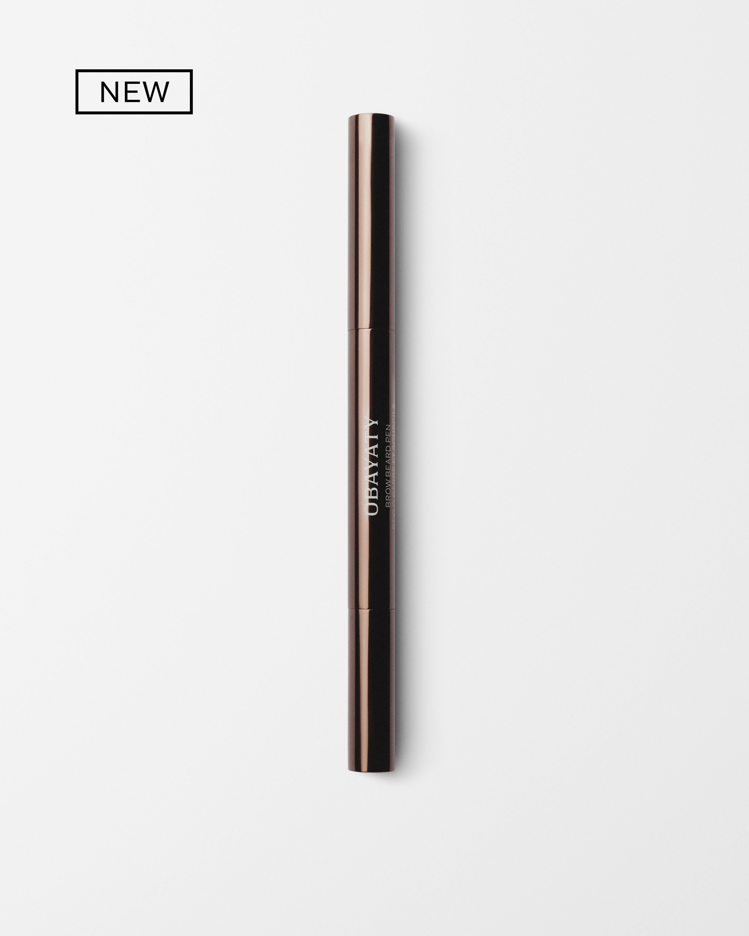 Men's brow beard pen laying on a grey surface