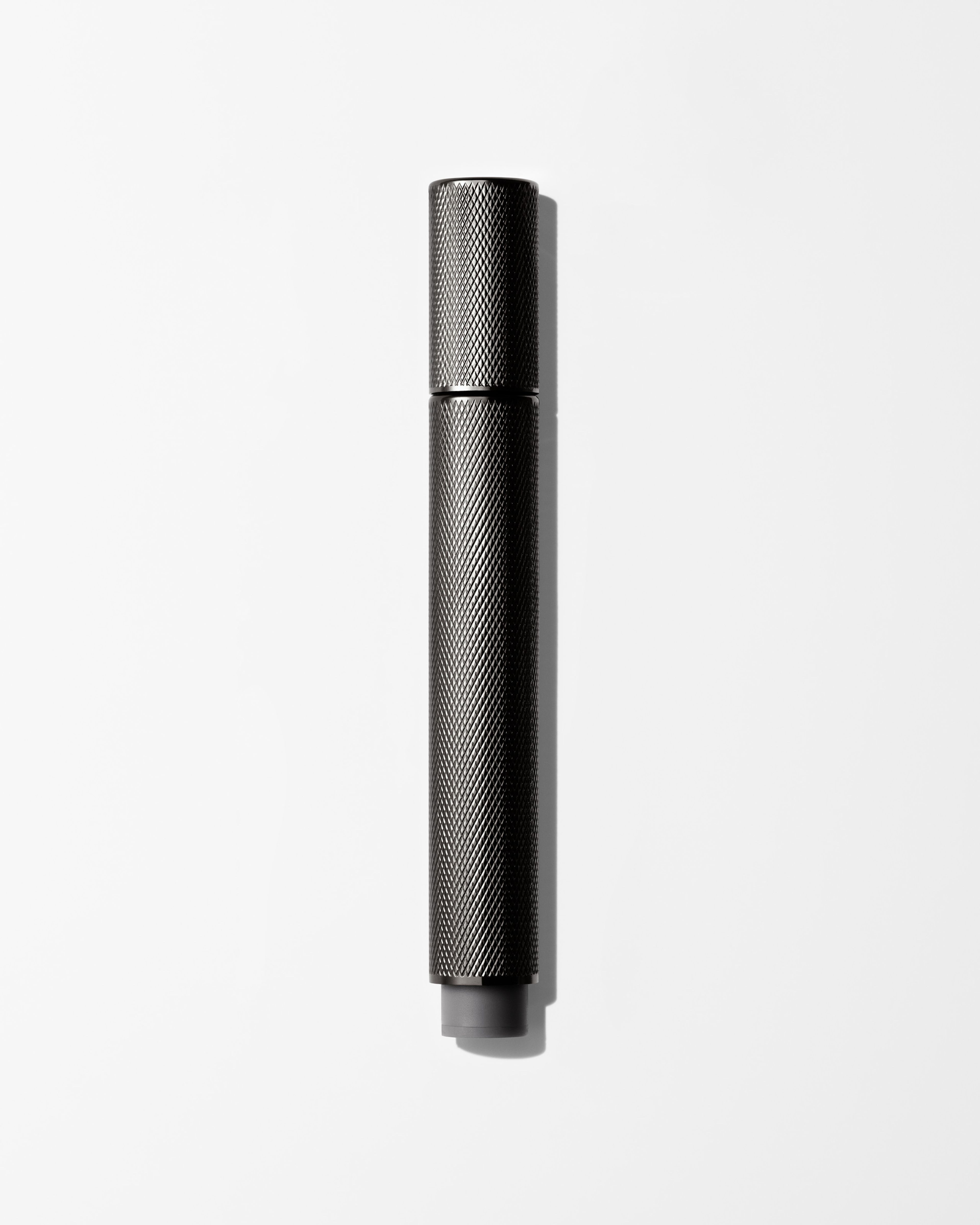 Men's tinted eye cream laying on a grey surface