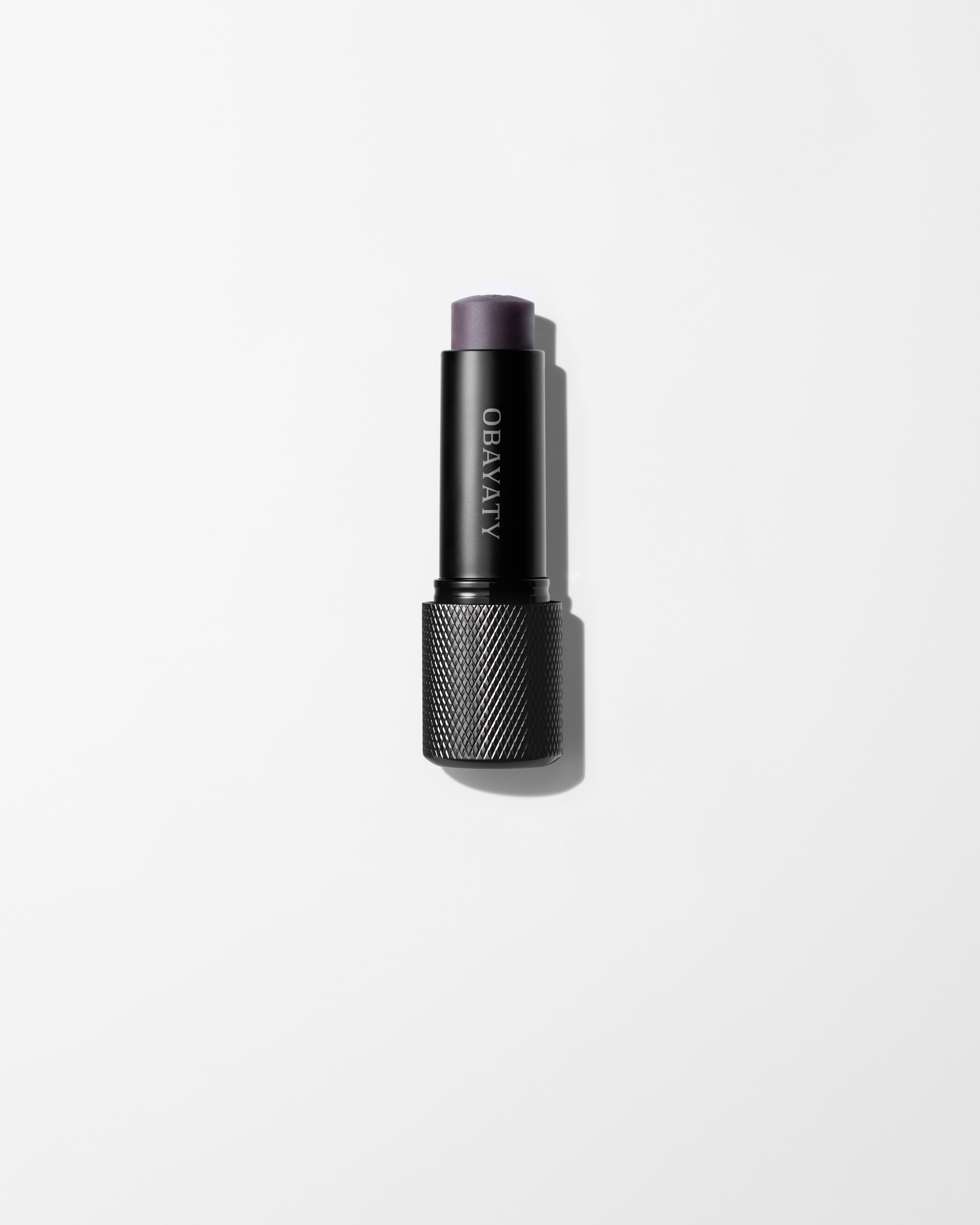 Enhancing Lip Balm laying on a grey surface