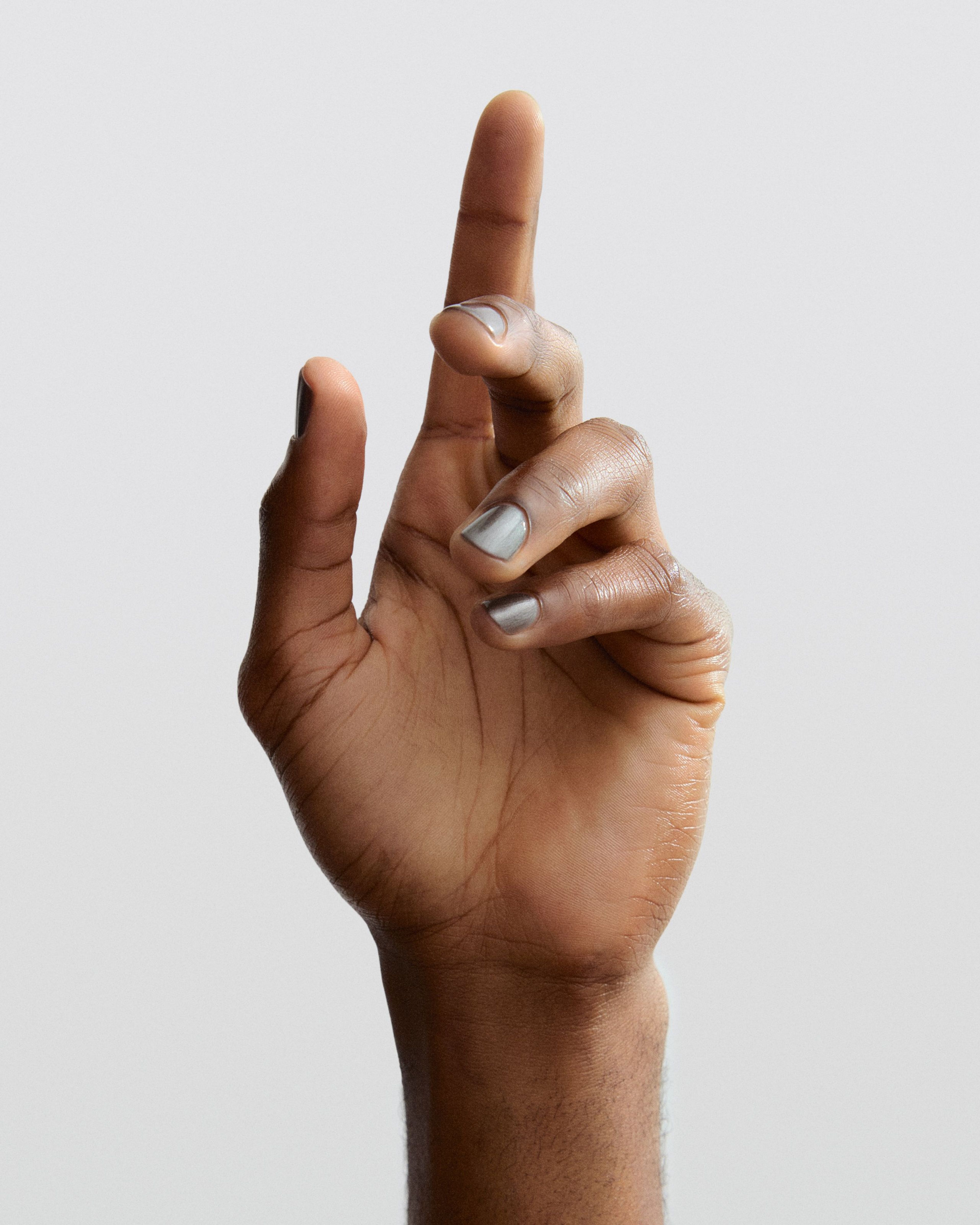 Man holding up his hand with Nail polish Off Black applied