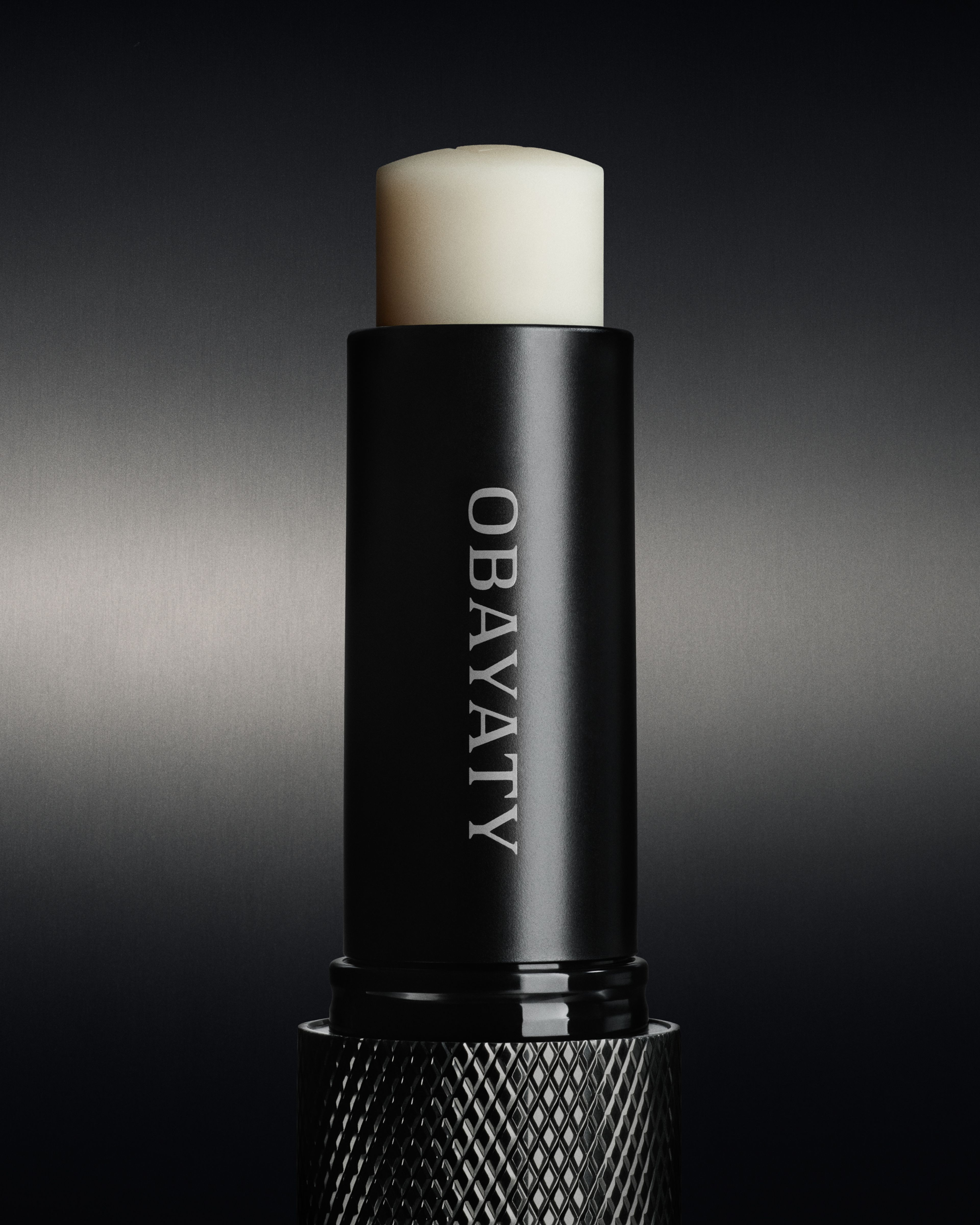 Close up of a lip balm for men in front of a dark metal background