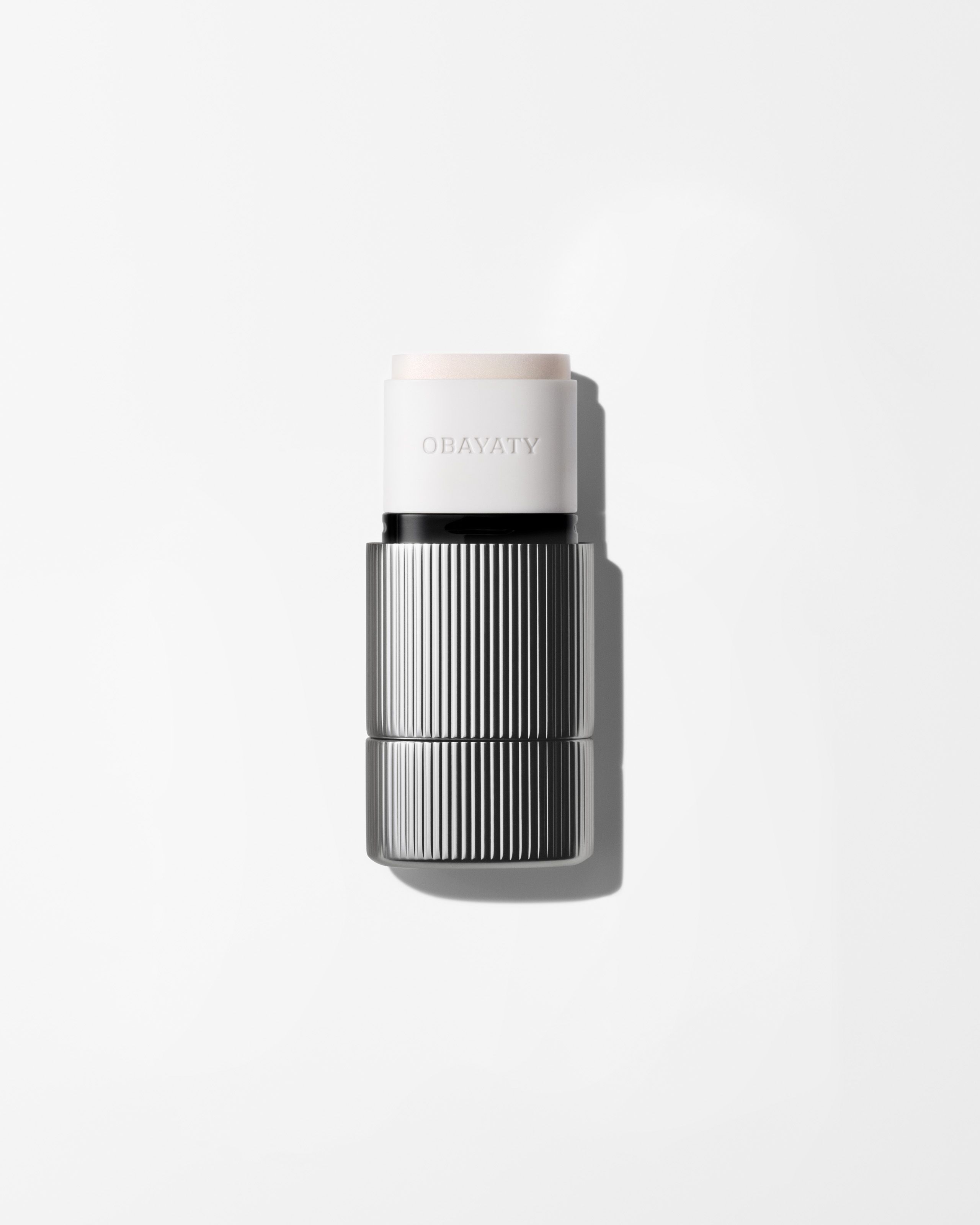 Silver highlighter stick packaging laying on a grey surface
