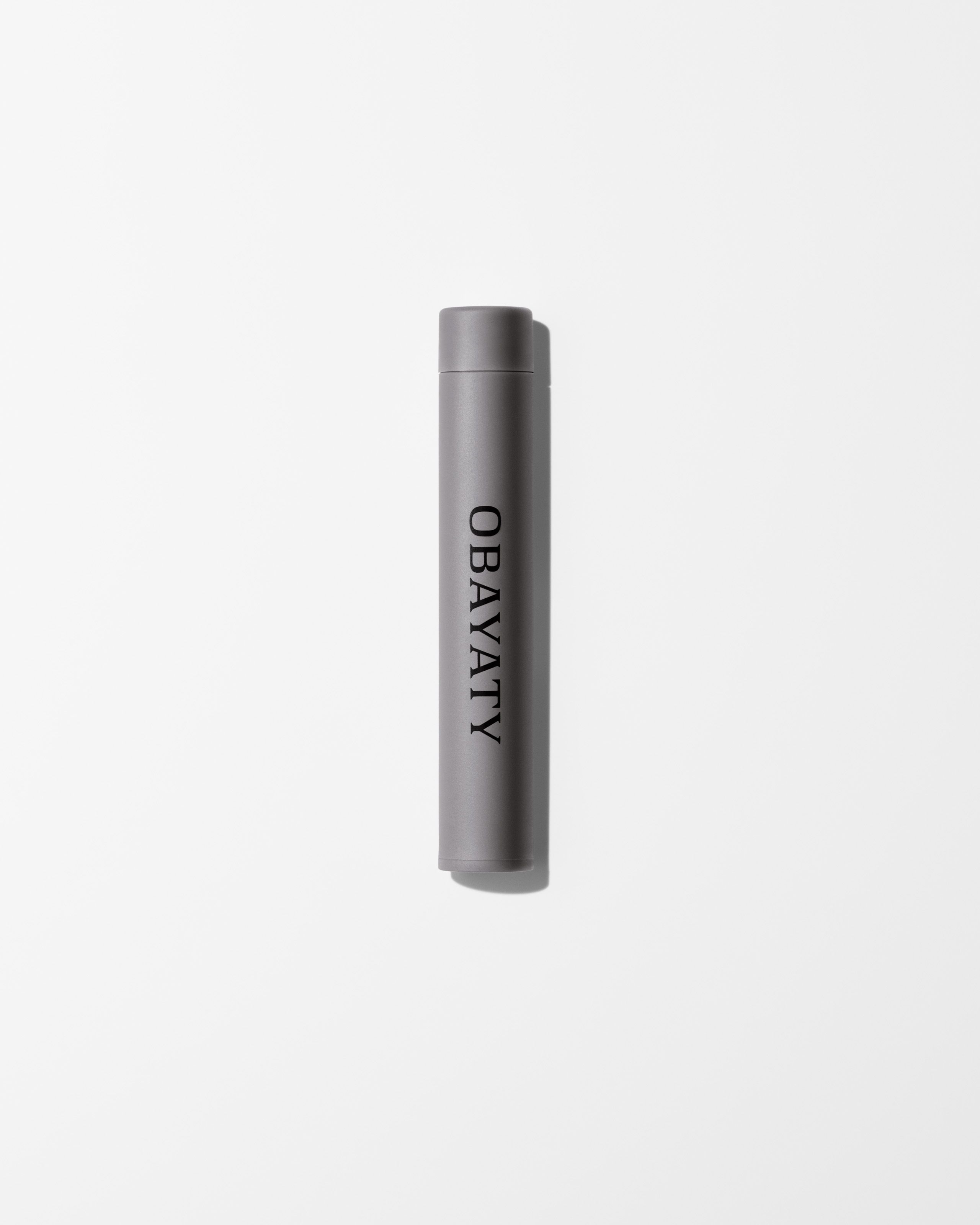 Tinted eye cream refill laying on a grey surface